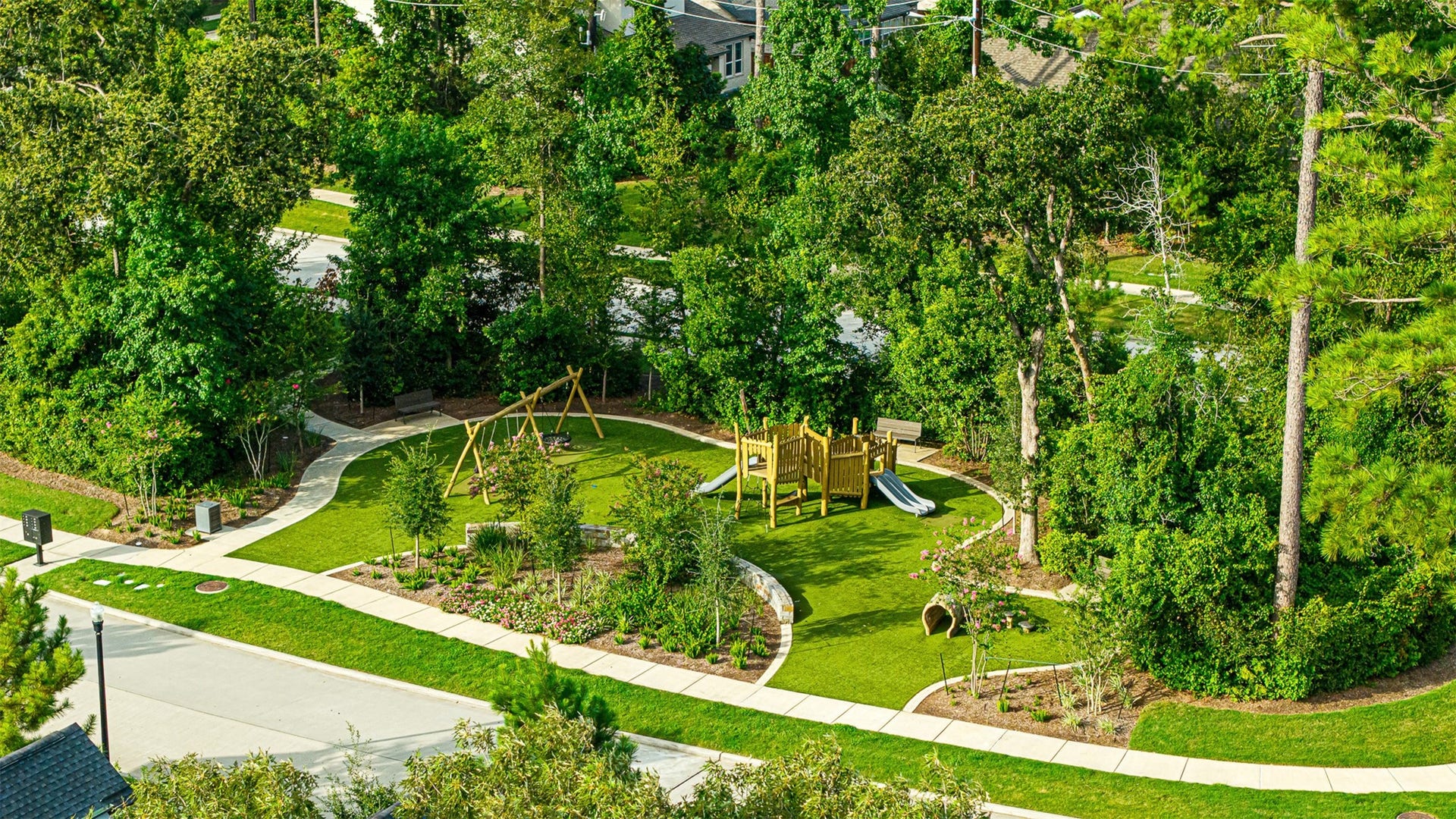 28314 Emerald Bend, Spring, TX 77386 Tucked amidst lush greenery, the community playground features wooden play structures, swings, and manicured turf surrounded by winding paved walking paths.