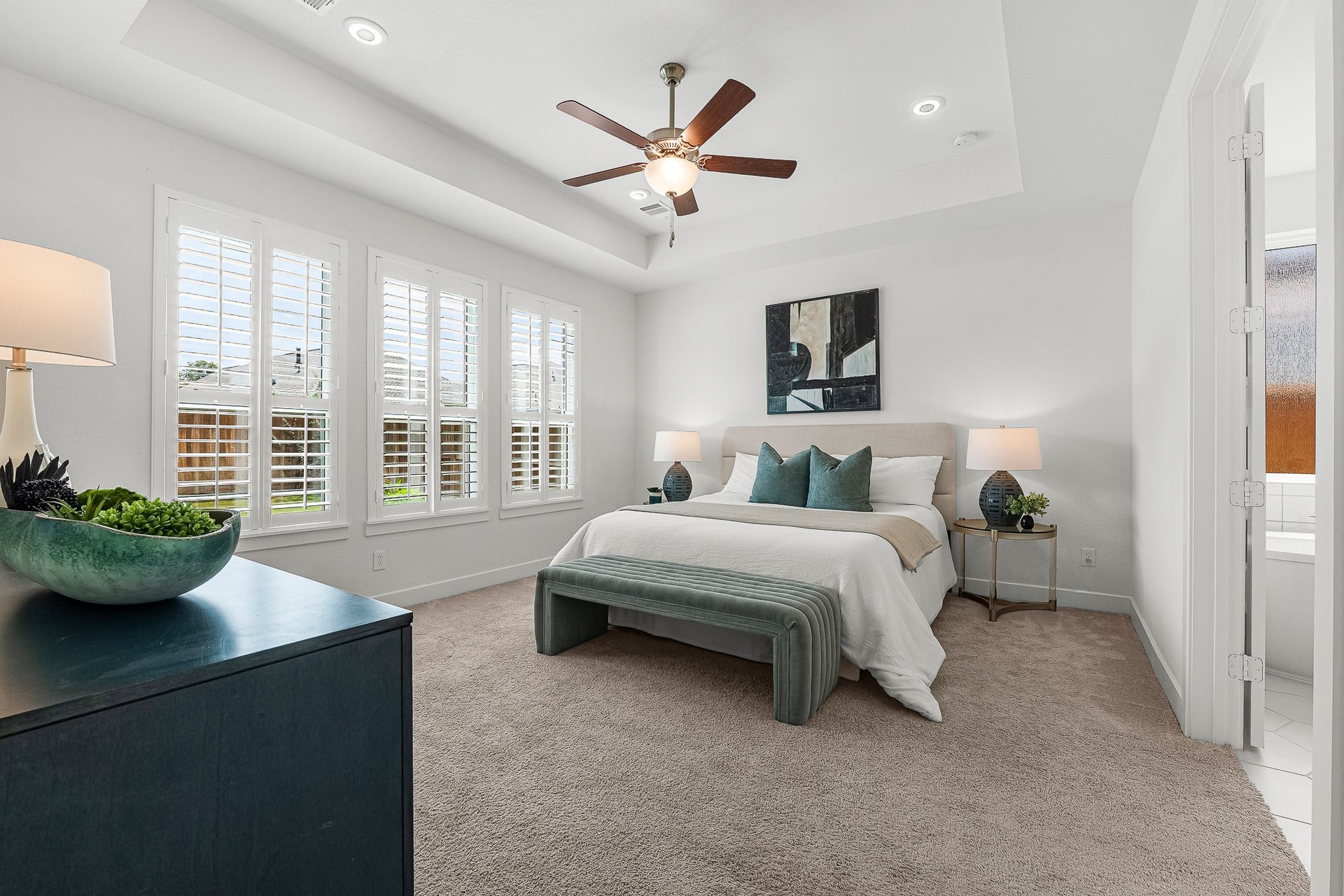 28314 Emerald Bend, Spring, TX 77386 High tray ceilings and classic plantation shutters enhance the spacious first-floor primary suite. Soft neutral carpeting and direct access to the private ensuite bath create a serene sanctuary designed for rest.