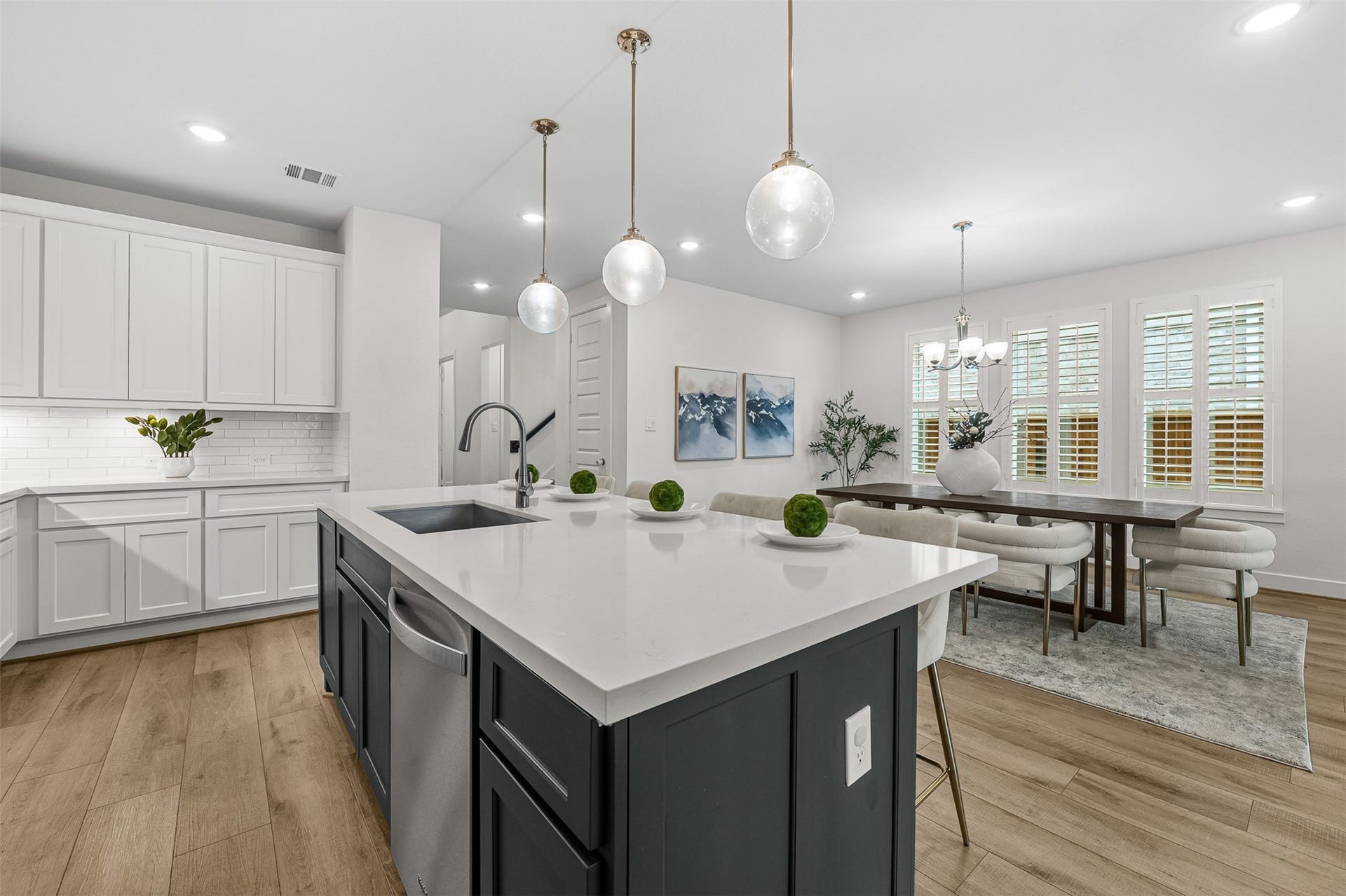 28314 Emerald Bend, Spring, TX 77386 Stylish pendant lights illuminate an oversized contrast island topped with quartz counters, seamless to the nearby dining nook. Clean white cabinetry, stainless steel appliances, and a subway tile backsplash complete this gourmet kitchen layout.