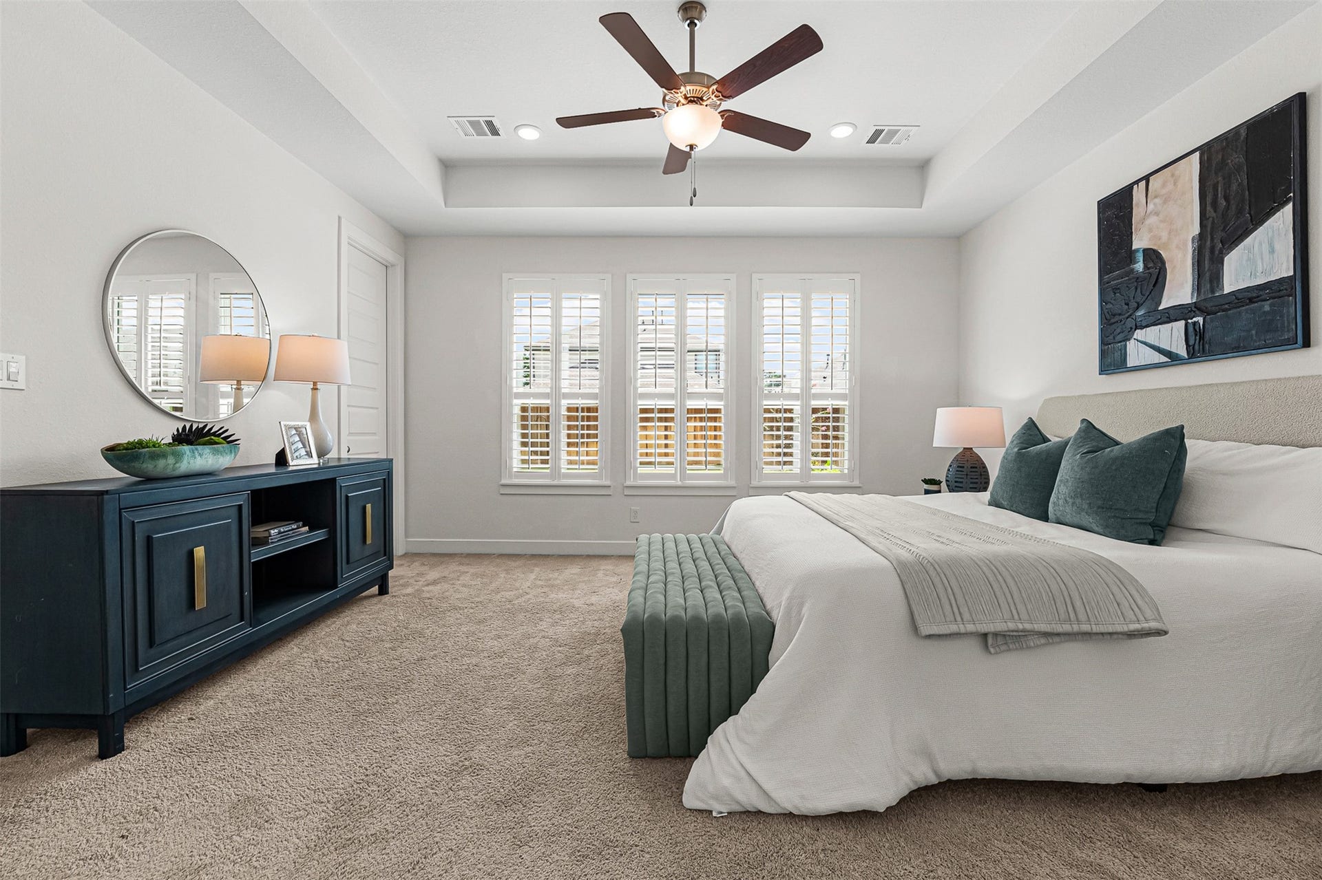 28314 Emerald Bend, Spring, TX 77386 A recessed tray ceiling with a stylish fan elevates the spacious primary suite on the first floor. Planted windows with plantation shutters frame neighborhood views, while soft carpet flooring creates an inviting atmosphere for relaxation.