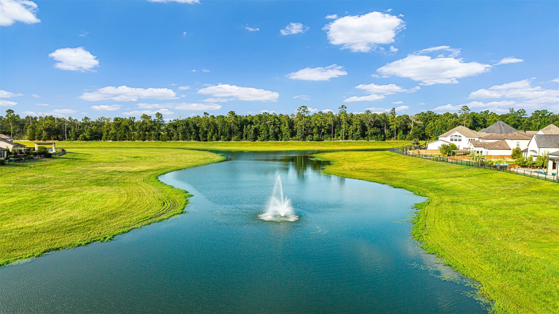 28314 Emerald Bend, Spring, TX 77386 Scenic catch-and-release pond with a central fountain features winding shorelines framed by manicured green space and neighborhood homes.