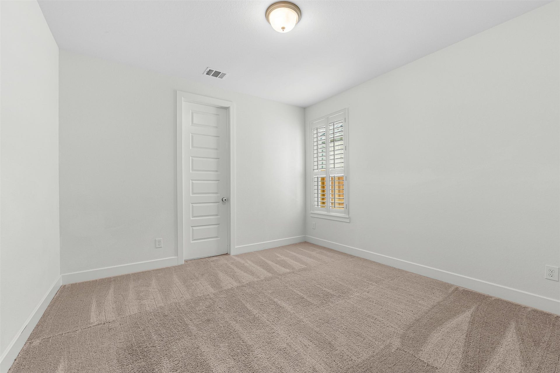 28314 Emerald Bend, Spring, TX 77386 Plush carpet flooring and crisp plantation shutters define this sunlit secondary bedroom, creating a peaceful and versatile space. Crisp white walls and a six-panel interior door complete the bright, neutral design.