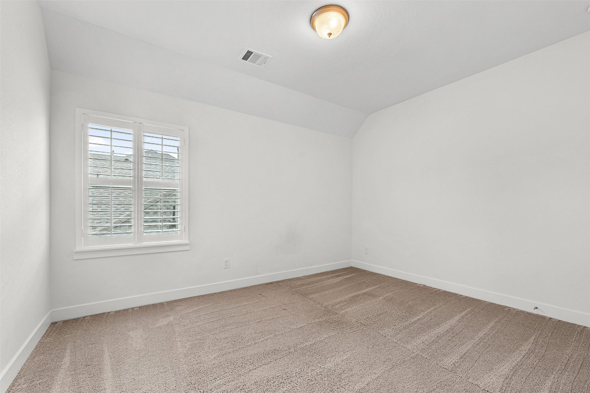 28314 Emerald Bend, Spring, TX 77386 Plush neutral carpeting and classic white plantation shutters define this sunlit secondary bedroom. Sloped ceiling accents and crisp white walls enhance the versatile space.