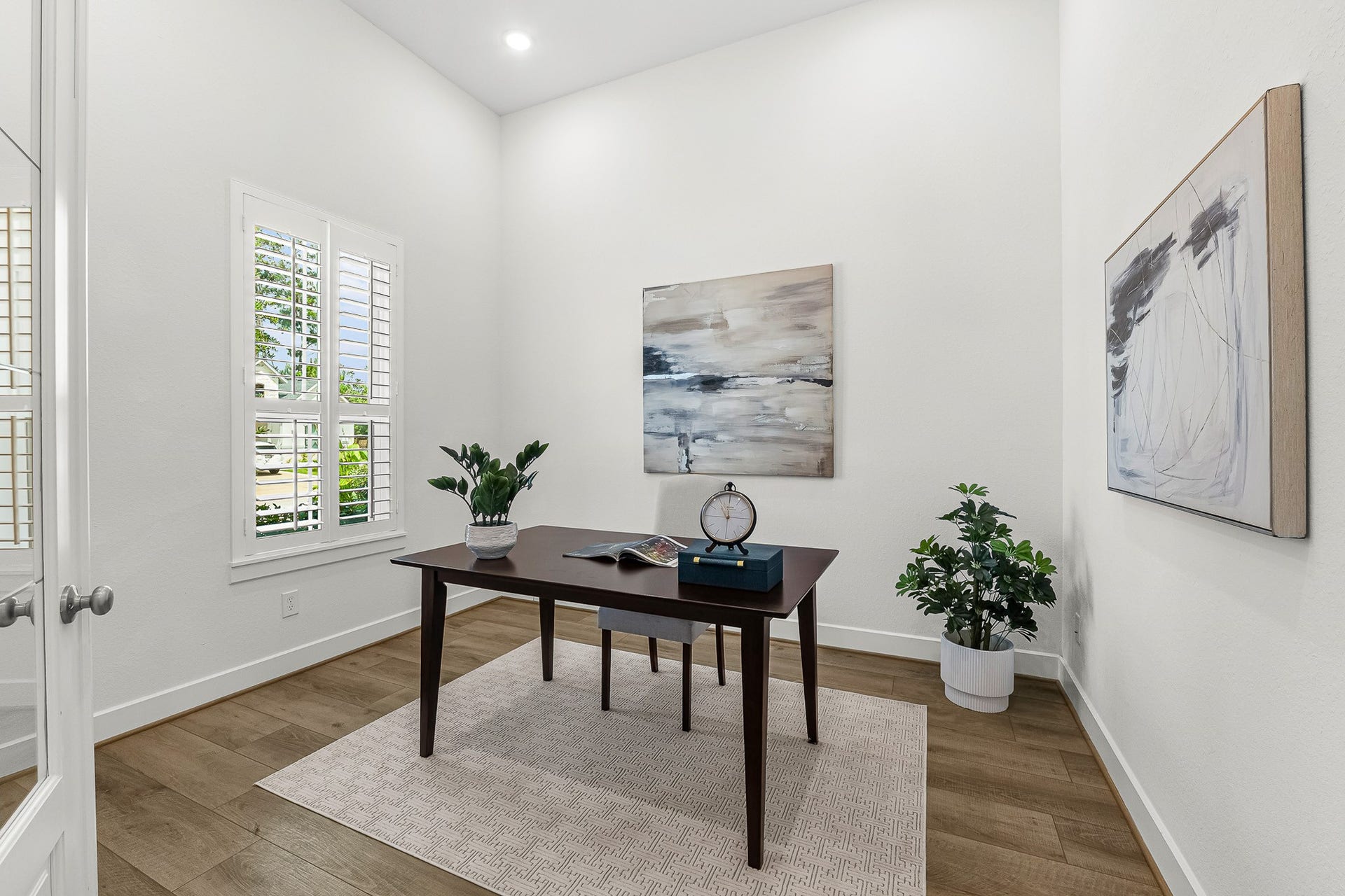 28314 Emerald Bend, Spring, TX 77386 Tucked behind elegant French doors, this private study features crisp plantation shutters, warm wood-look floors, and soaring ceilings. Thoughtfully positioned on the main level, the light-filled space provides a serene, quiet atmosphere for remote work or study.