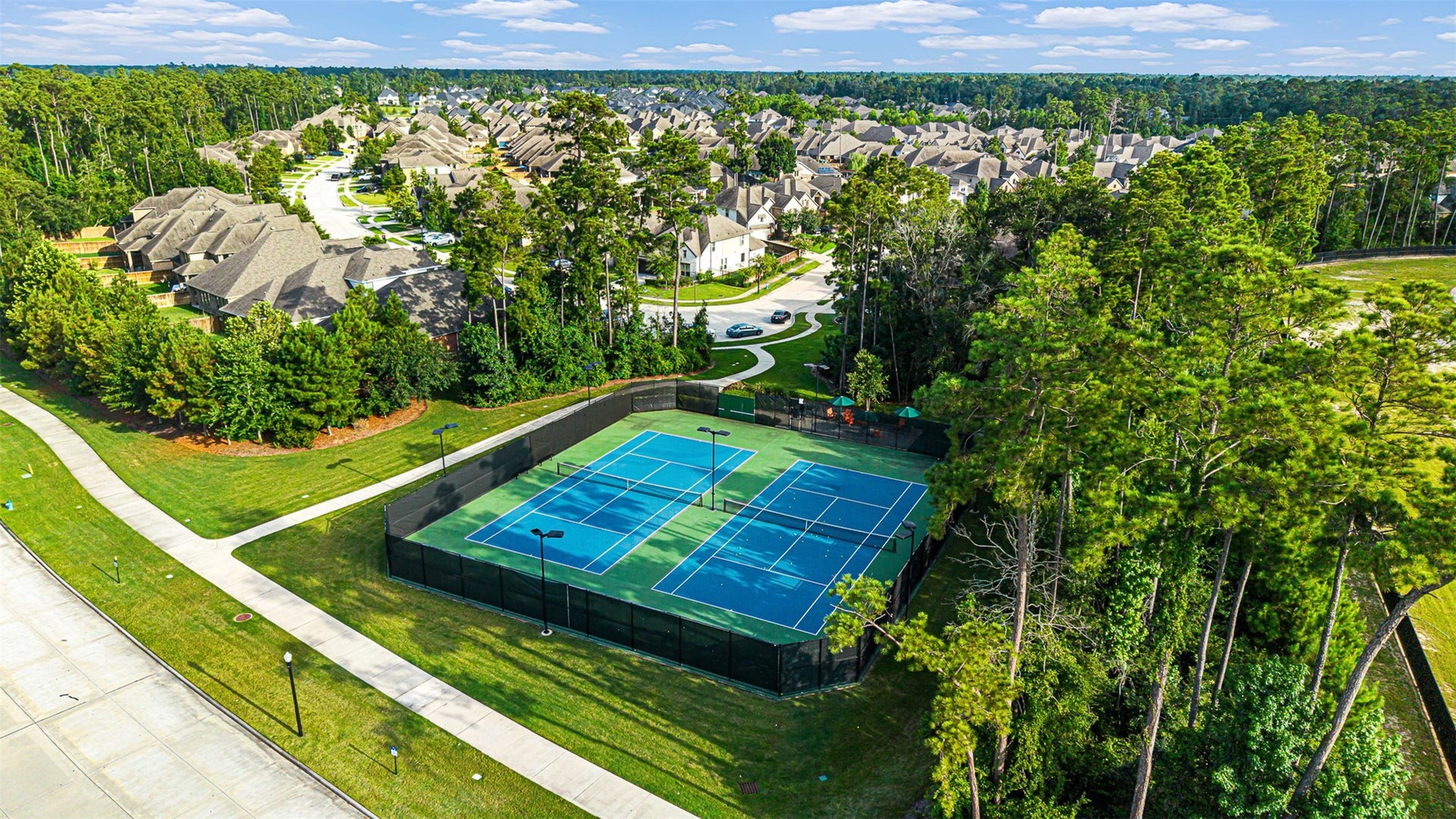 28314 Emerald Bend, Spring, TX 77386 Enjoy friendly matches on the vibrant community tennis courts, beautifully enclosed by protective fencing and tall pine trees.