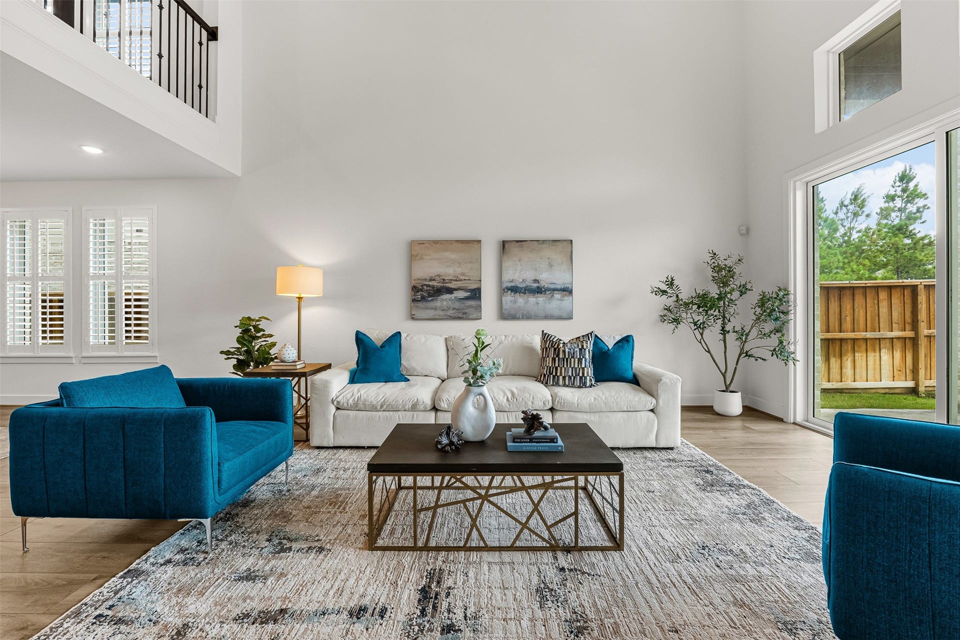 28314 Emerald Bend, Spring, TX 77386 Soaring two-story ceilings and a second-floor catwalk overlook highlight this bright, open-concept first-floor living space. Sliding glass doors frame views of the private fenced yard, while planter shutters add polished privacy to the airy room.