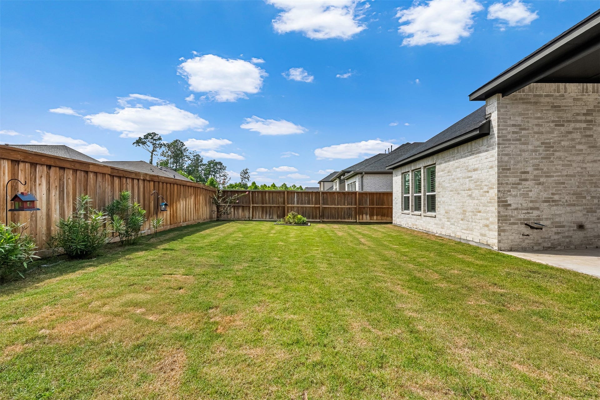 28314 Emerald Bend, Spring, TX 77386 Expansive green space and a high privacy fence define this level backyard, offering endless possibilities for outdoor enjoyment.