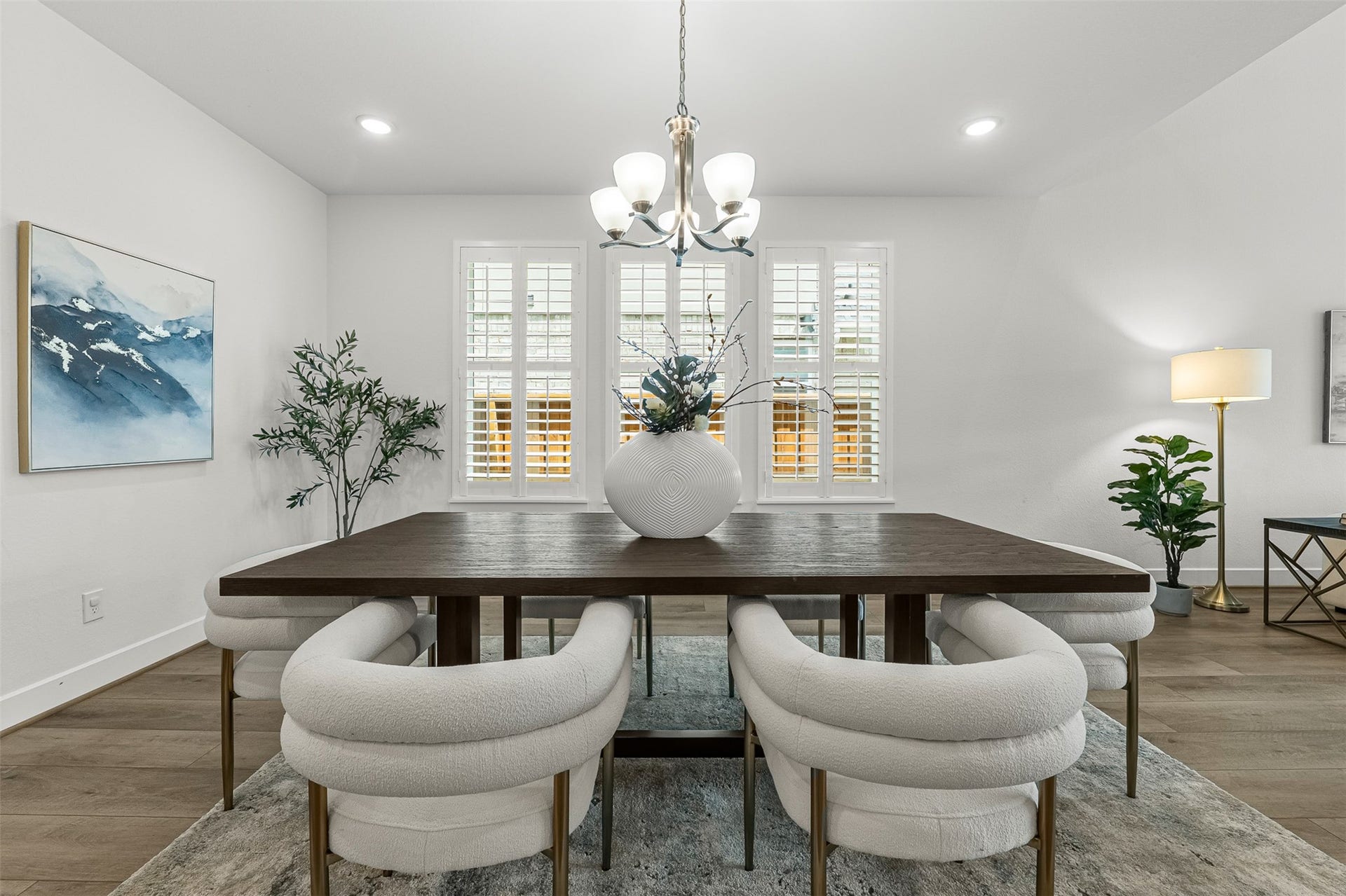 28314 Emerald Bend, Spring, TX 77386 Elegant plantation shutters and a classic multi-light chandelier frame this spacious formal dining room with soft, ambient illumination. Open to the surrounding living spaces, the room easily accommodates a large dining table atop sleek wood-look flooring.