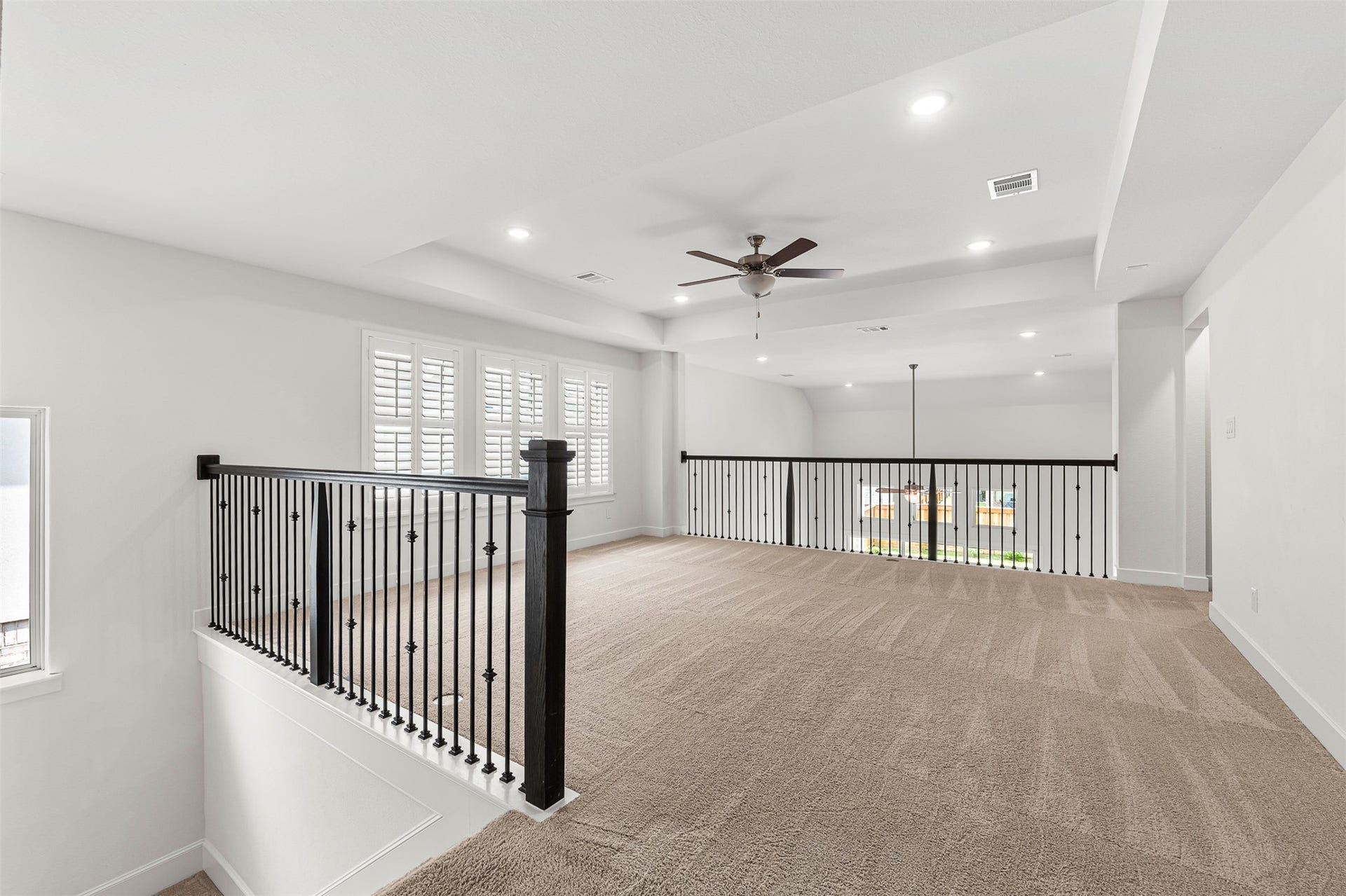 28314 Emerald Bend, Spring, TX 77386 Perched above the main living area, this versatile second-floor flex space features plush carpeting, wrought-iron railings, and classic plantation shutters. The airy open loft overlooks the lower level, creating an ideal spot for an upstairs game room or casual lounge.