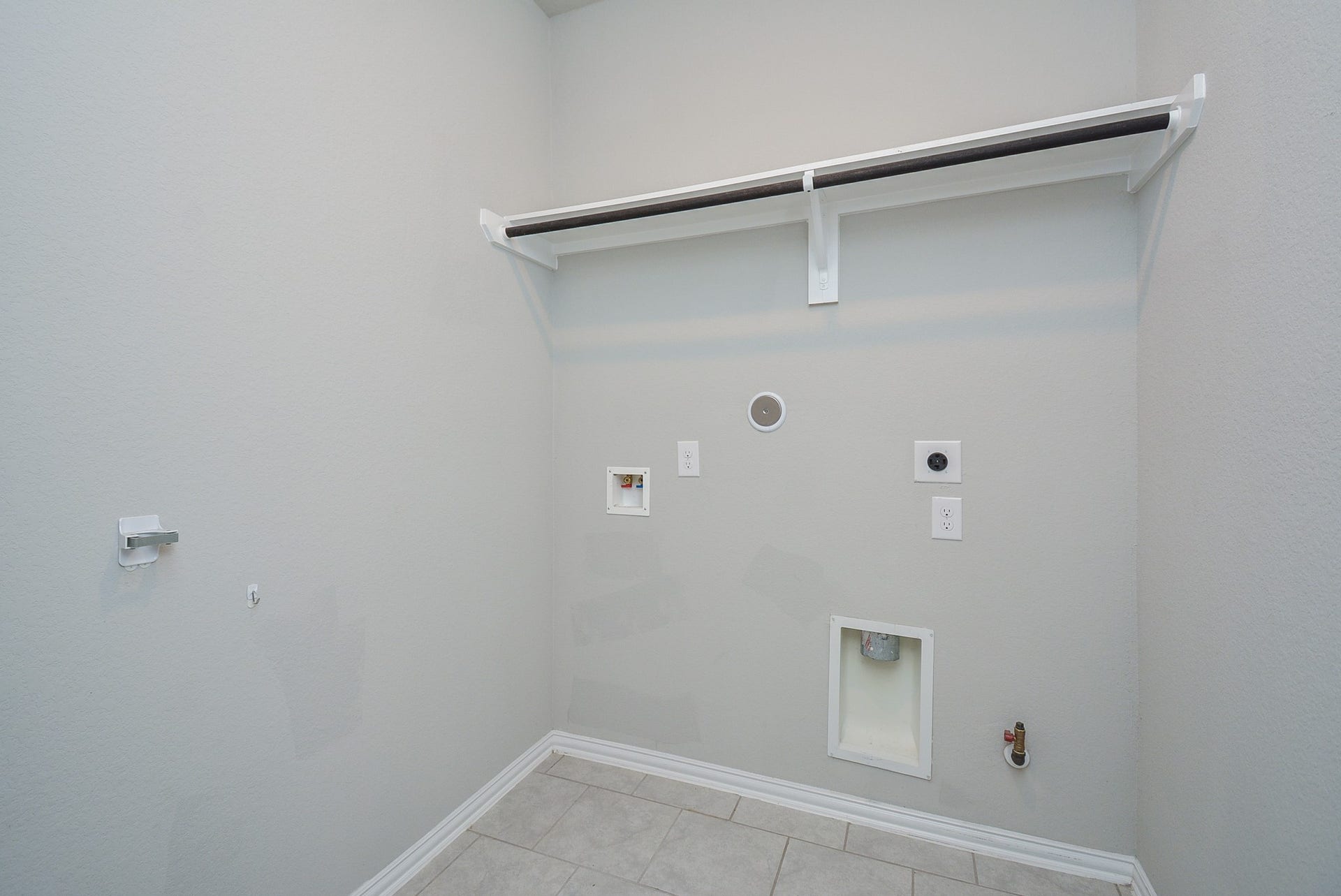 7450 French Quarter Court, Fulshear, TX 77441 The utility space is ready for dual laundry appliances, with handy shelving above.