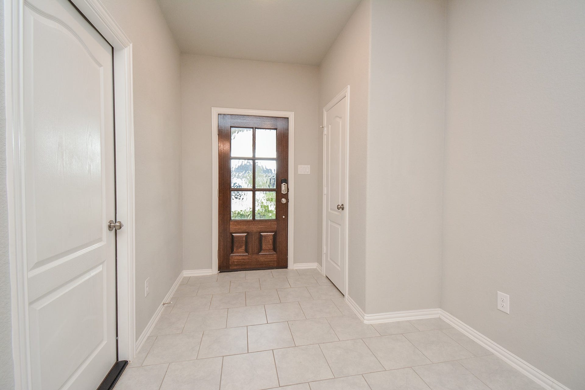 7450 French Quarter Court, Fulshear, TX 77441 The front entrance/foyer from the inside is bright with pale, neutral walls and beautiful tile flooring, which covers all common areas. (The bedrooms are carpeted.)
