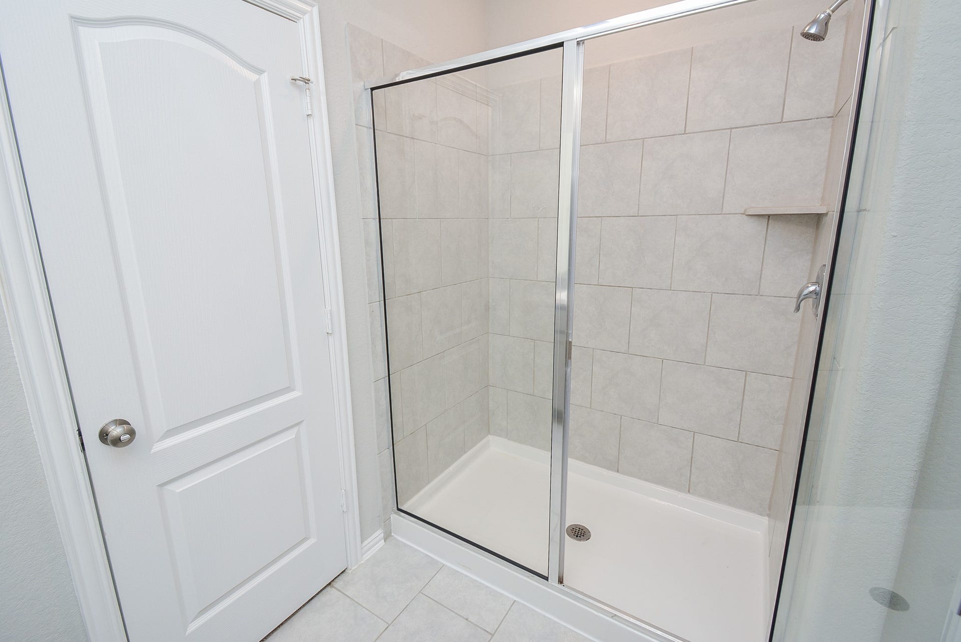 7450 French Quarter Court, Fulshear, TX 77441 A roomy walk-in, glass enclosed shower with great big, good looking tile, is so convenient.