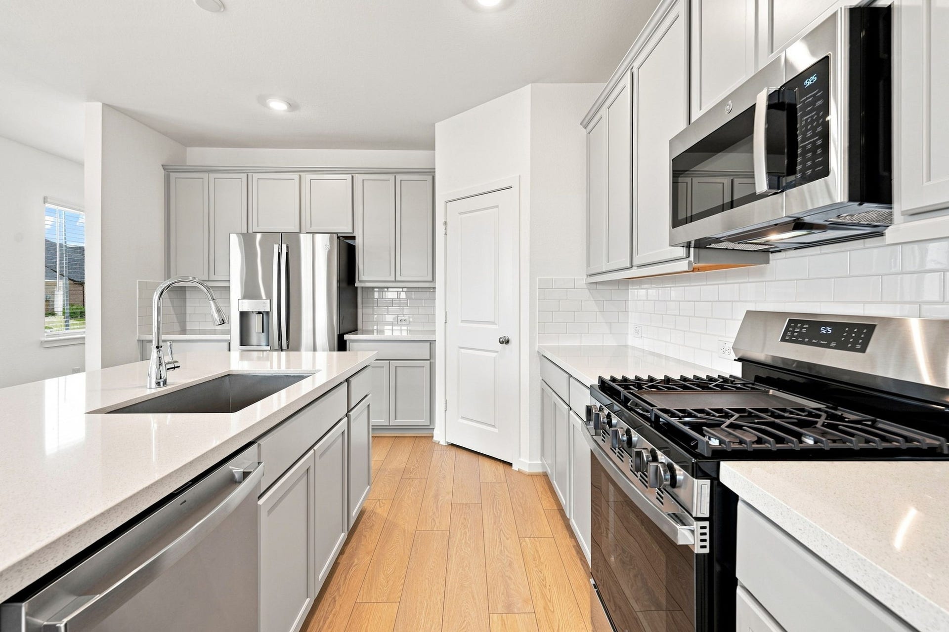 139 High Life Crossing, Richmond, TX 77469 Clean lines, classic cabinetry, and stainless-steel appliances create a polished kitchen, while the oversized island provides an impressive focal point and valuable workspace.