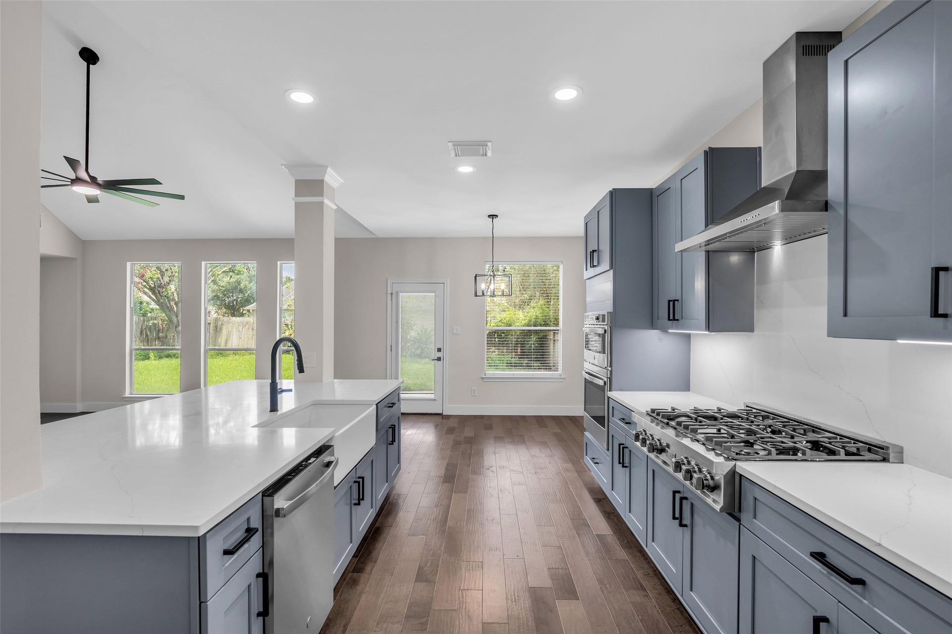 22002 Madera Canyon Court, Richmond, TX 77469 Sleek kitchen with modern cabinetry, a spacious island with a sink, and stainless steel appliances, all under elegant recessed lighting.