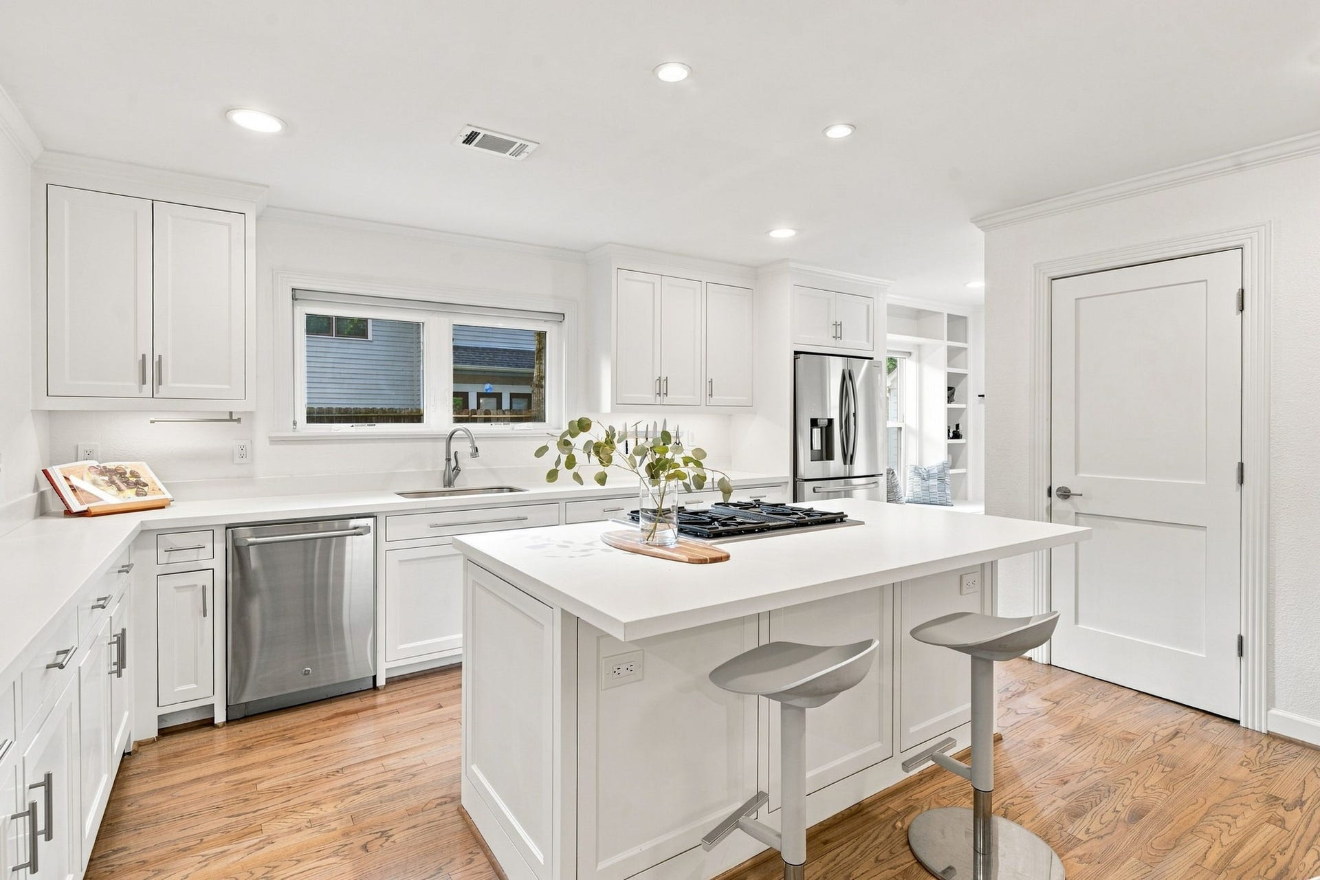Kitchen island with prep space and storage, GE Cafe dishwasher, window over the sink.