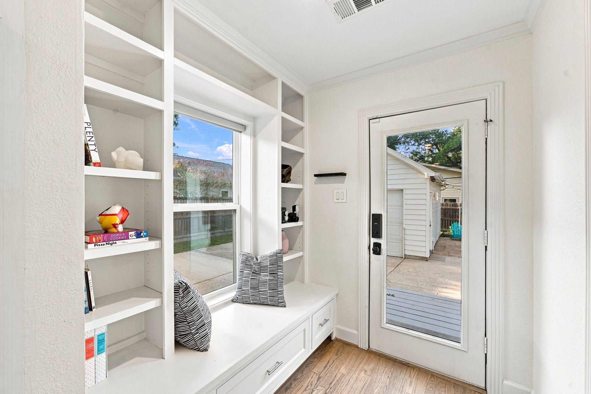 Built-in bookshelves beside a glass-paned door to the backyard. Refinished hardwoods. All windows updated to double paned.