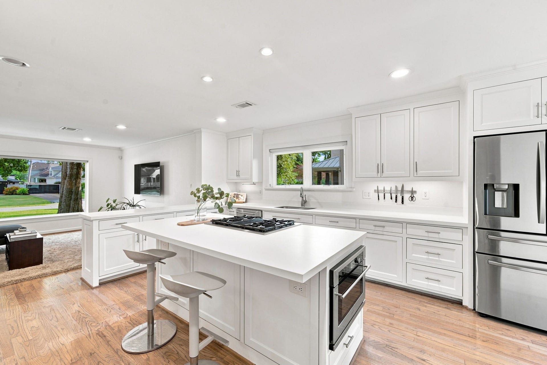 Island kitchen with seating, Jenn-Air dual-fuel range, GE Cafe appliances, open to the living room.
