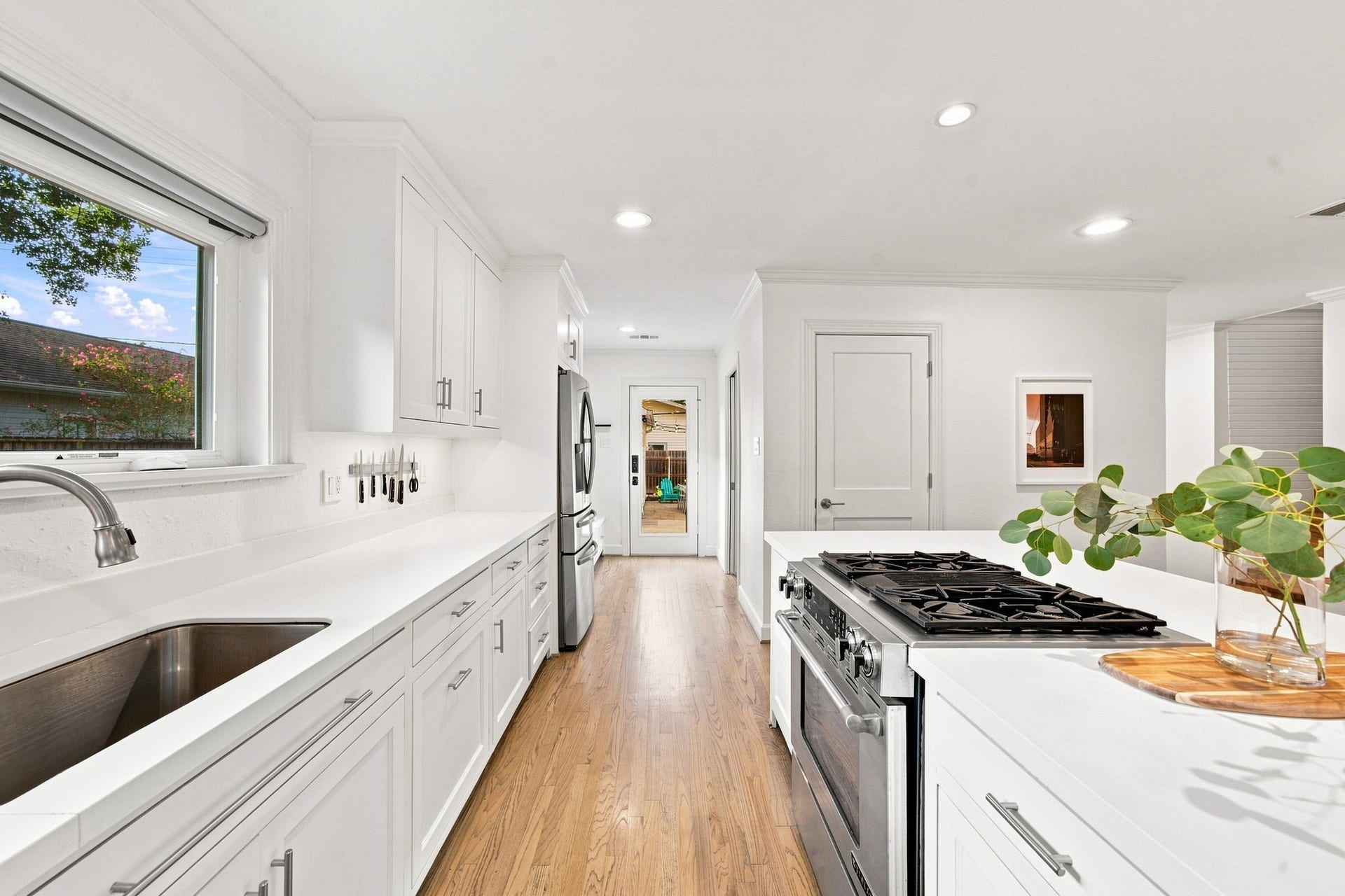 Sink to the Jenn-Air dual-fuel downdraft range in one long run of counter. Island across from it.