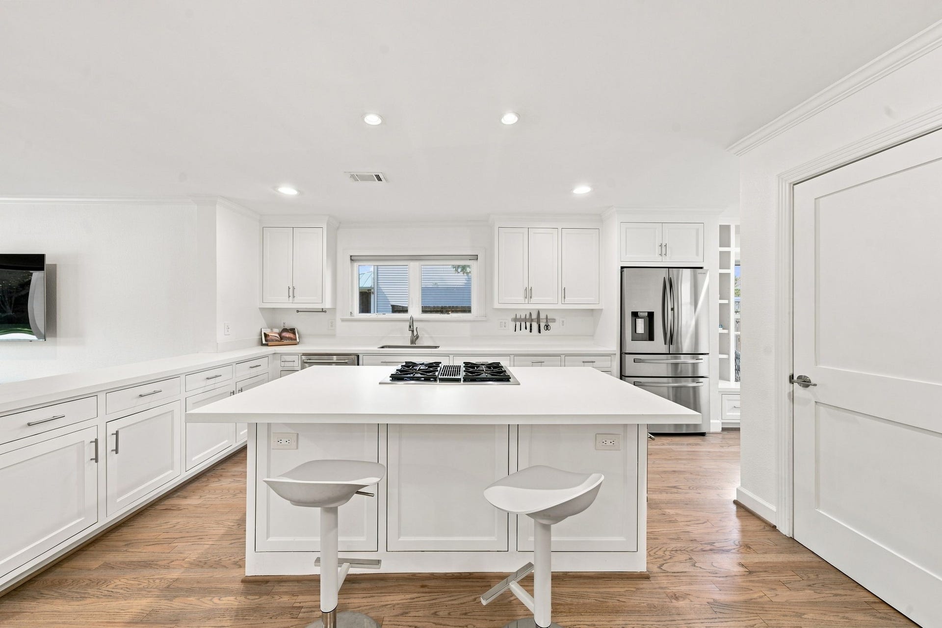 Kitchen from the dining side: island, Jenn-Air dual-fuel range, GE Cafe microwave oven (2024).