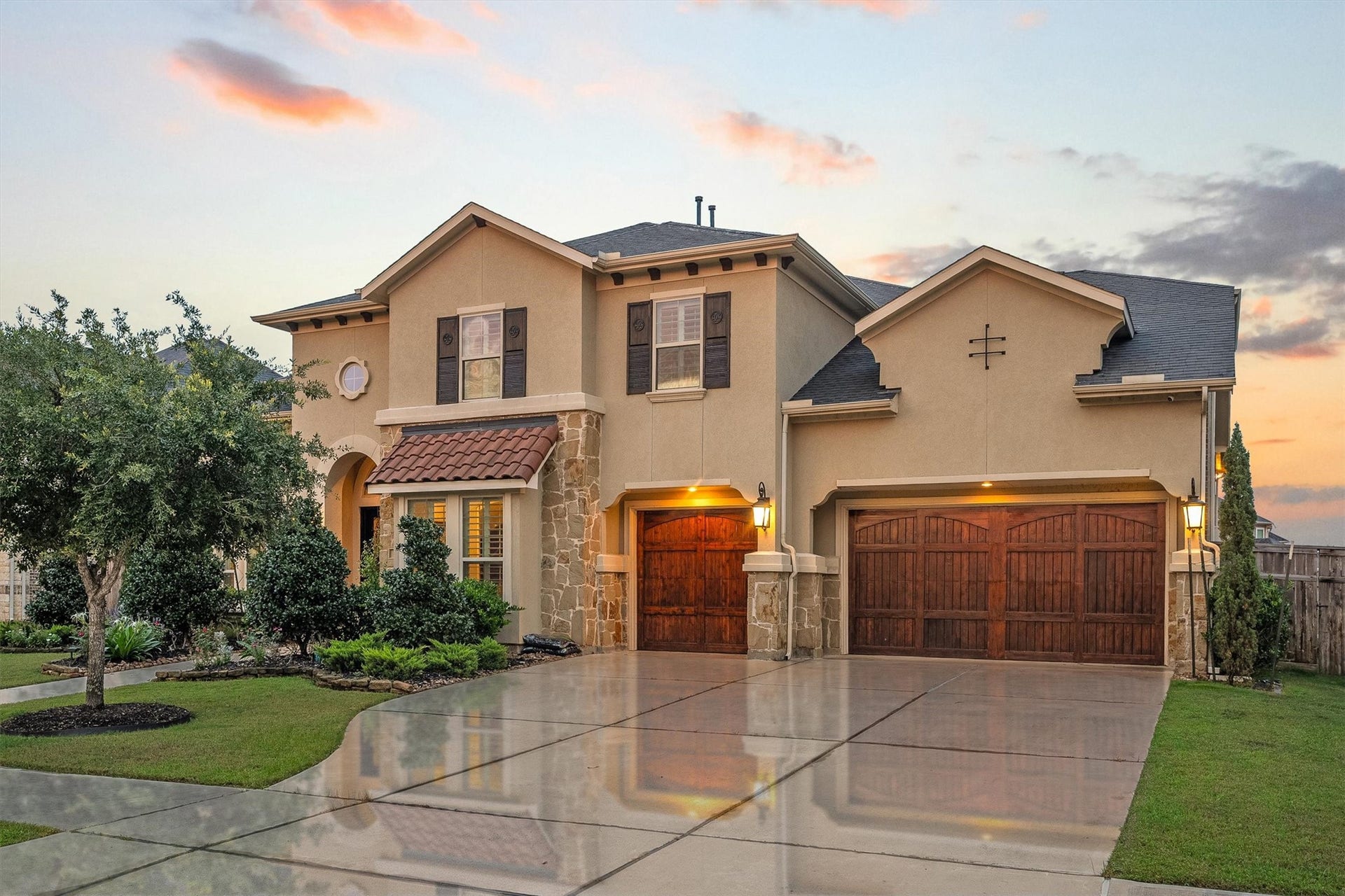 4822 Kendalia Cloud Lane, Fulshear, TX 77441 Twilight view highlighting the home's impressive curb appeal and three-car garage.