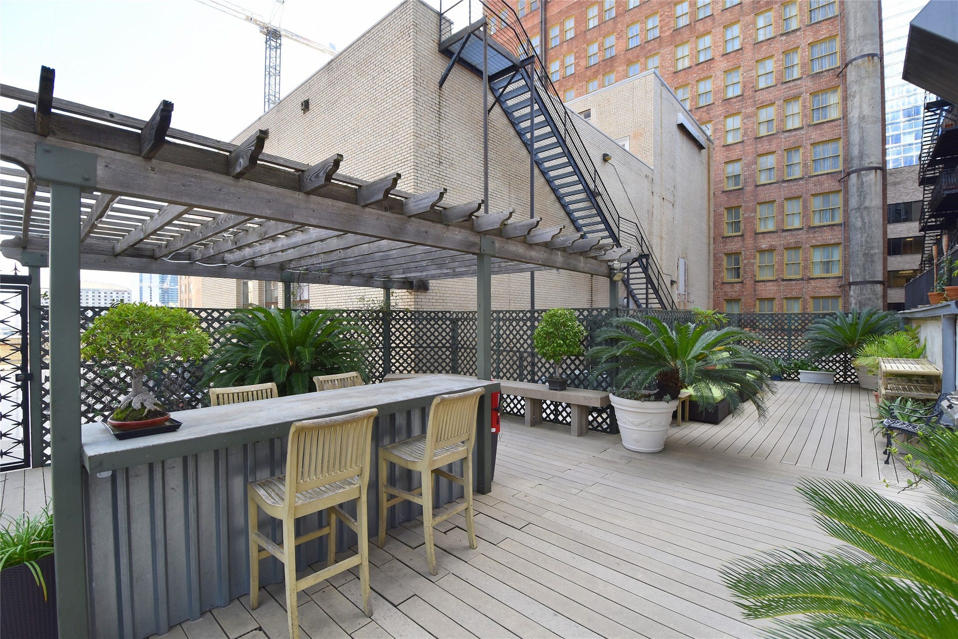 705 Main Street, #215, Houston, TX 77002 Spacious urban rooftop deck with a pergola, bar seating.