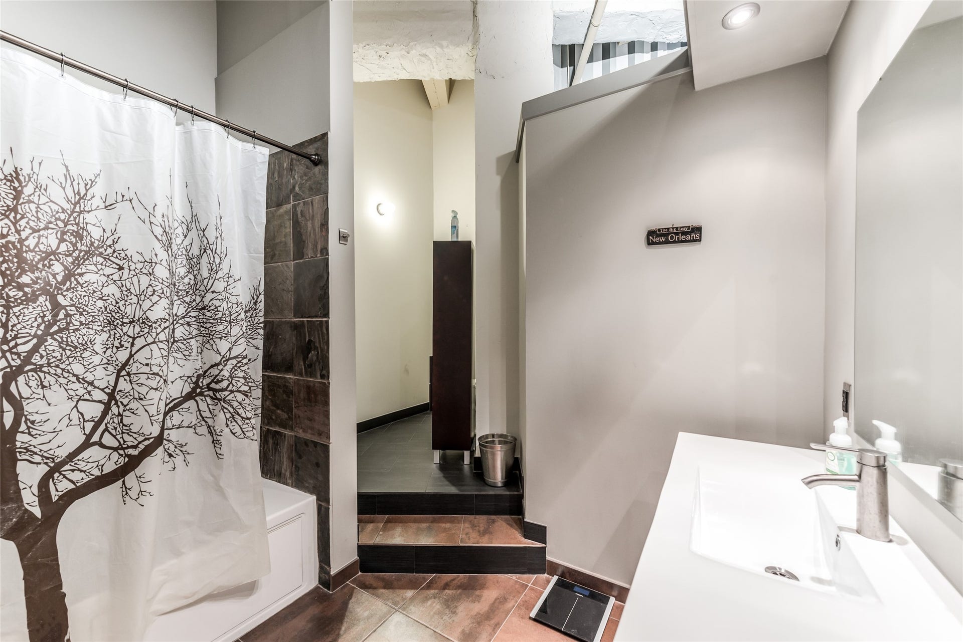 705 Main Street, #215, Houston, TX 77002 Secondary Bathroom features a modern design with slate tile accents, and a sleek white vanity.