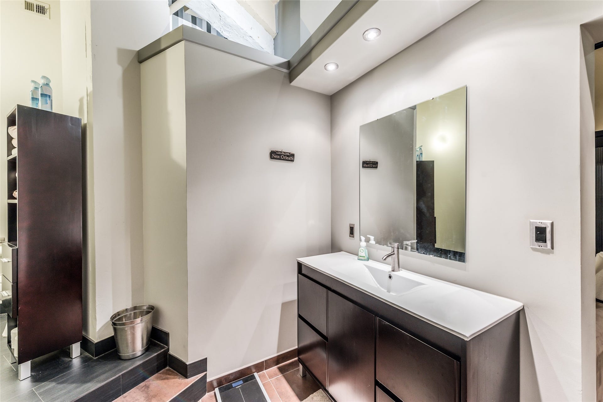 705 Main Street, #215, Houston, TX 77002 Secondary Bathroom features a modern vanity with a large mirror, recessed lighting, and sleek cabinetry.
