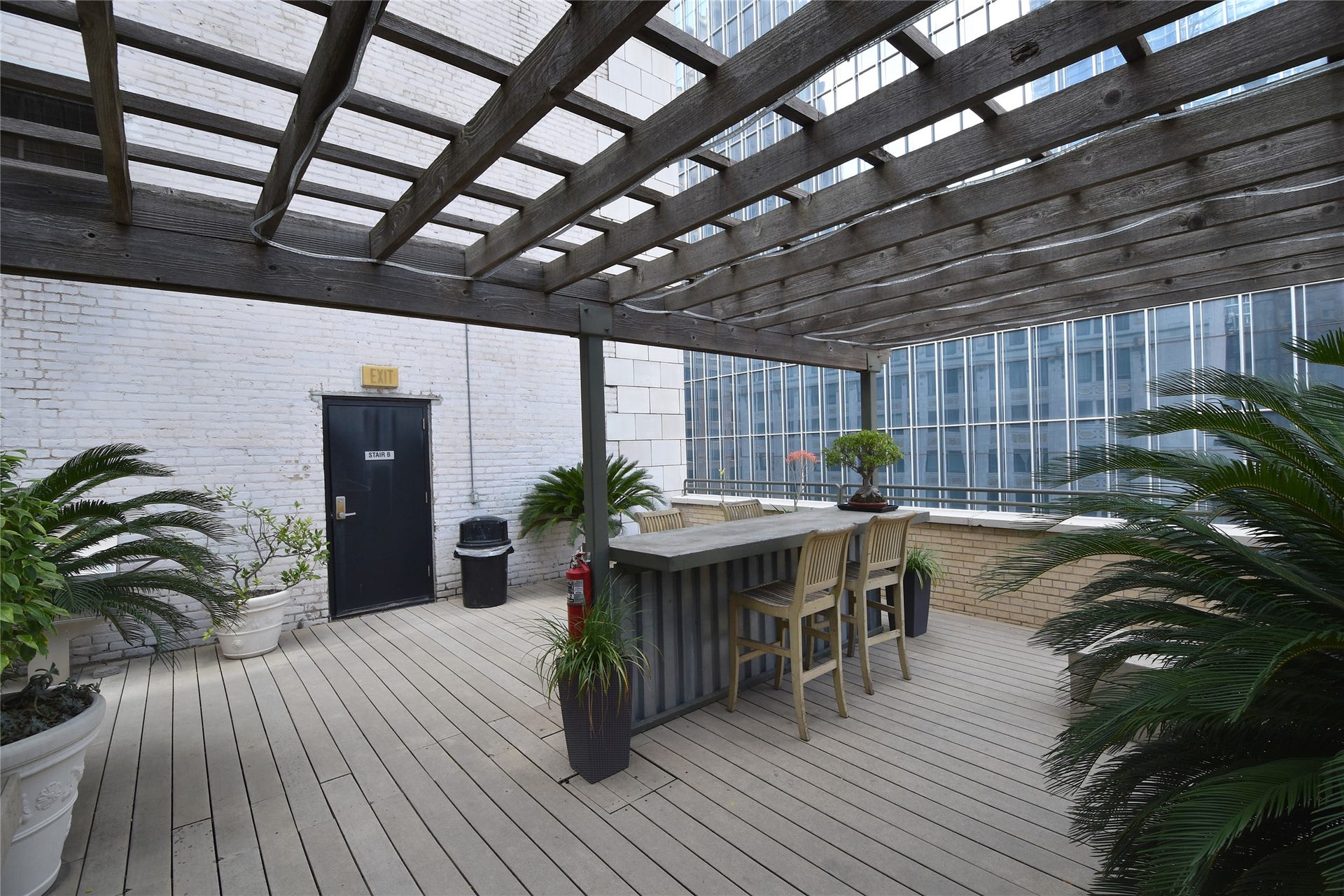 705 Main Street, #215, Houston, TX 77002 Stylish rooftop patio with a wooden pergola, bar seating.