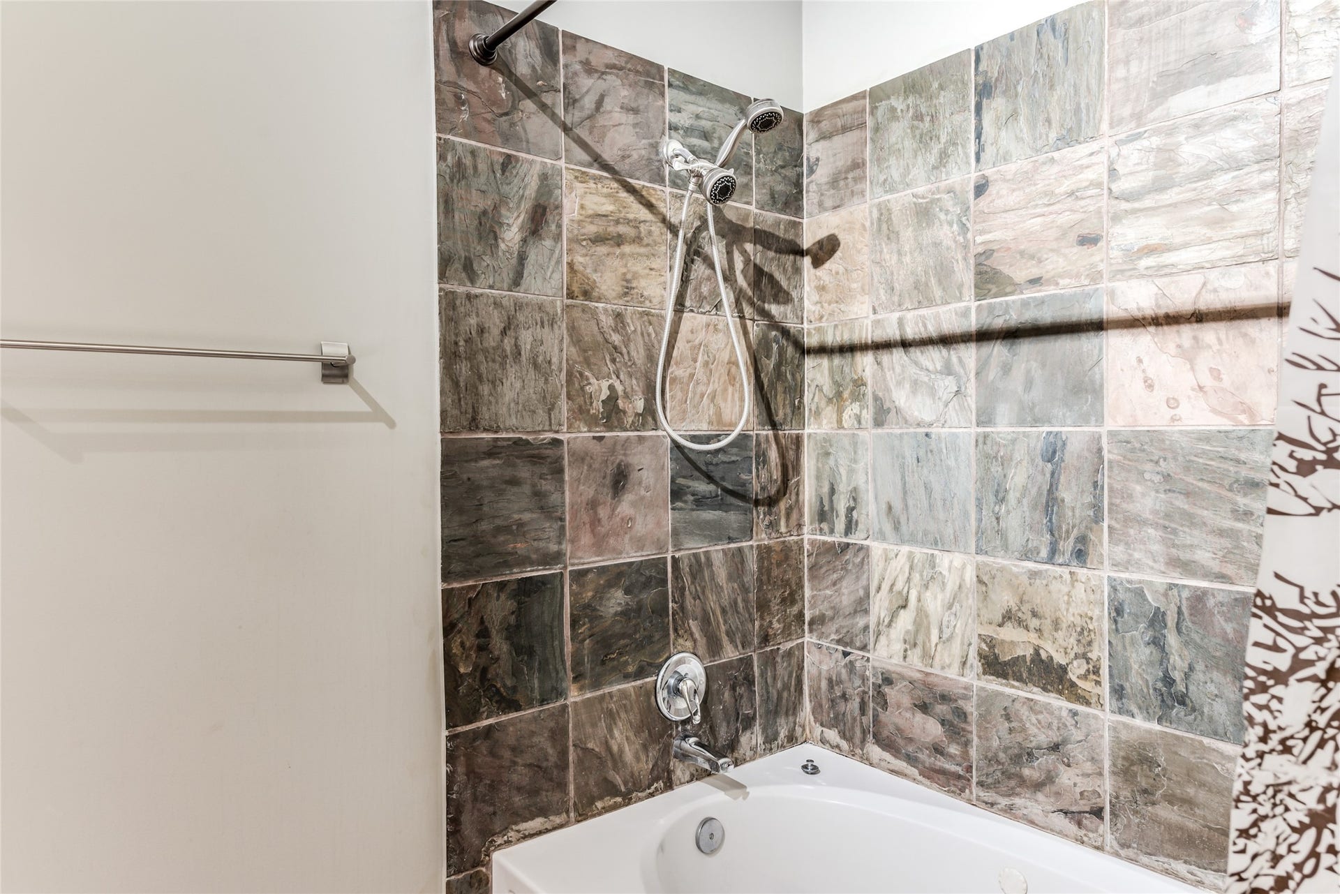 705 Main Street, #215, Houston, TX 77002 This bathroom features a tub-shower combination with a modern tile surround, offering a clean and stylish look.