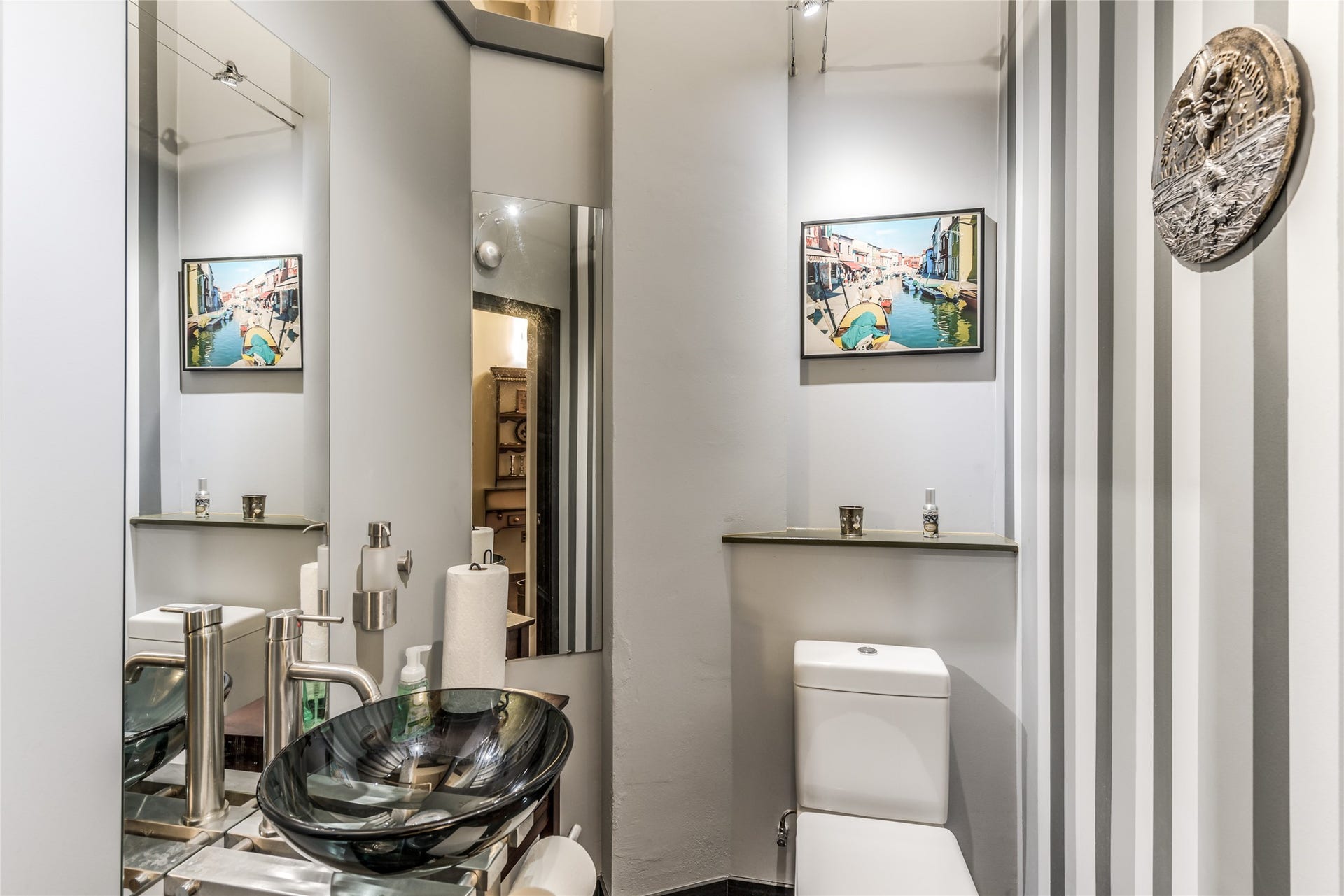 705 Main Street, #215, Houston, TX 77002 Half Bath features a sleek glass vessel sink, elegant fixtures, and stylish striped walls.