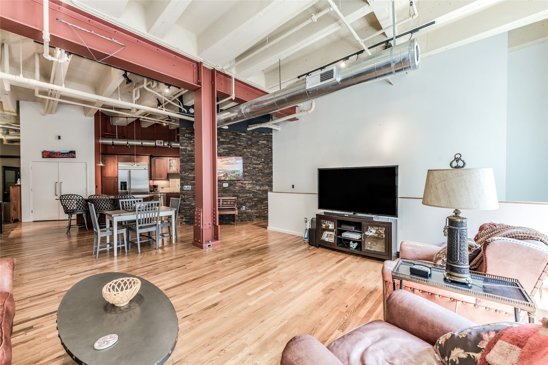 705 Main Street, #215, Houston, TX 77002 This open-concept loft features high ceilings with exposed beams and ductwork, hardwood floors, and a mix of industrial and rustic elements.