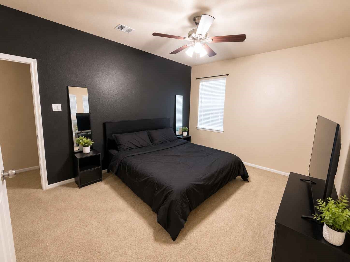 21570 Spear Valley Lane, Porter, TX 77365 Spacious secondary bedroom offers plenty of room for a full bedroom setup, with a ceiling fan, natural light and a bold accent wall that adds character to the space