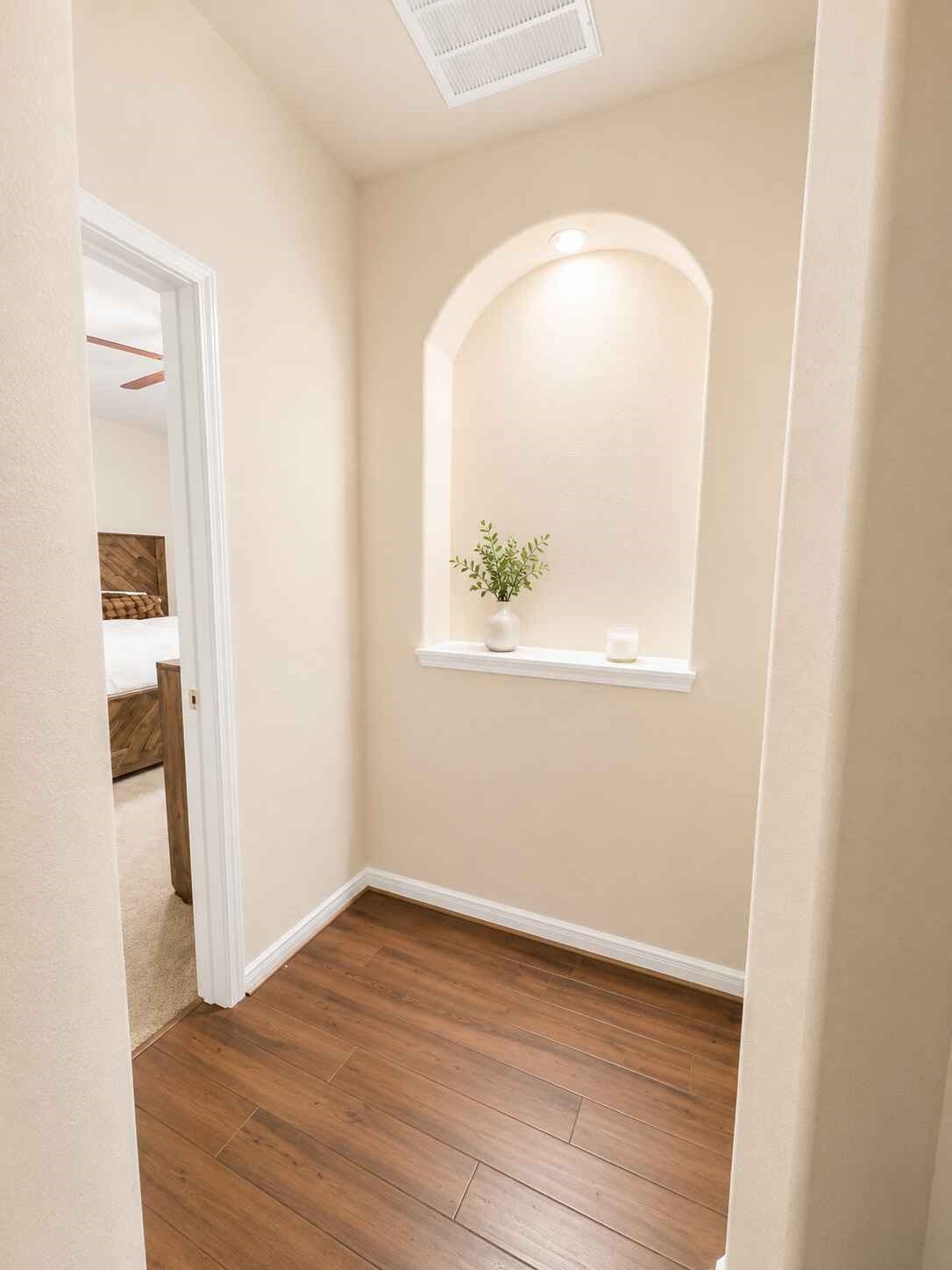 21570 Spear Valley Lane, Porter, TX 77365 Thoughtfully designed hallway features warm wood-look flooring and a charming arched nichean ideal spot for decor, artwork or a personal touch