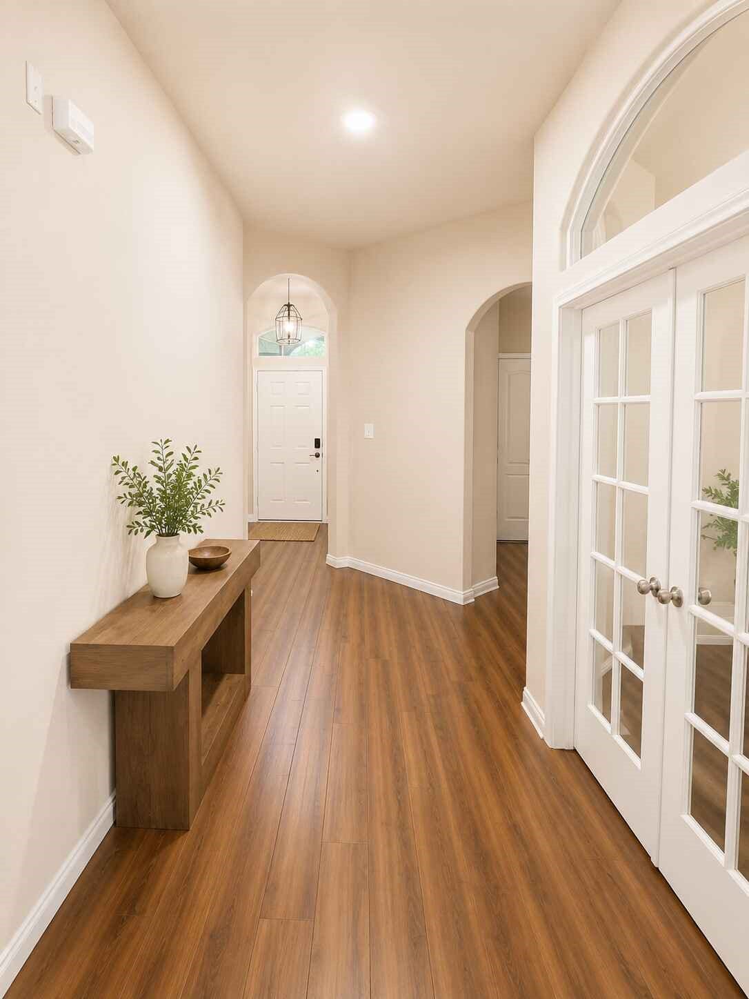 21570 Spear Valley Lane, Porter, TX 77365 A wide entry hallway with warm wood-look flooring, high ceilings and graceful architectural arches leads into the heart of the home, while French doors create a defined and versatile space just off the entry