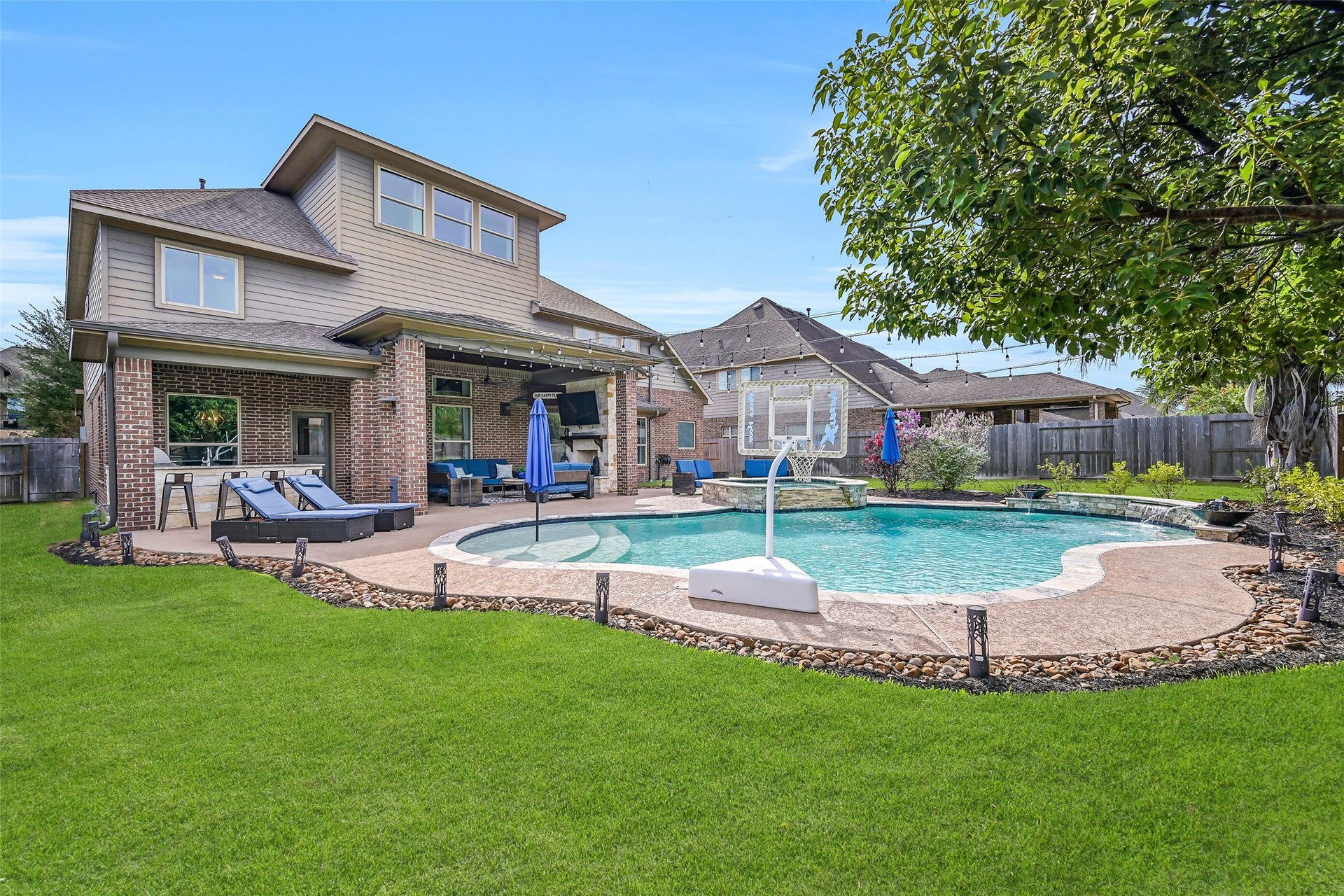 This wide backyard view captures the full resort-style settingheated pool and spa, expansive covered patio with fireplace, outdoor kitchen, multiple seating areas and landscaped lawnall just steps from the home.