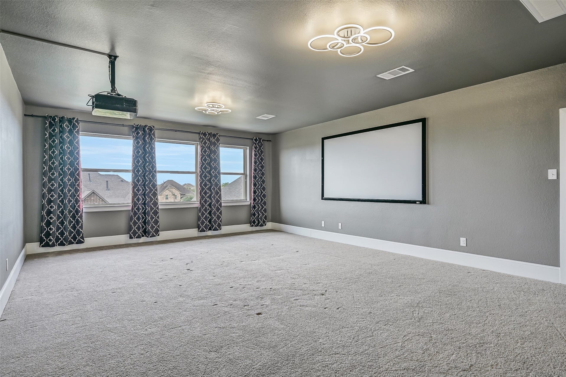 Ready for movie nights and game days, the expansive third-floor media room includes the mounted projector and large screen, plus a component closet and its own half bath. Projector & screen are included!
