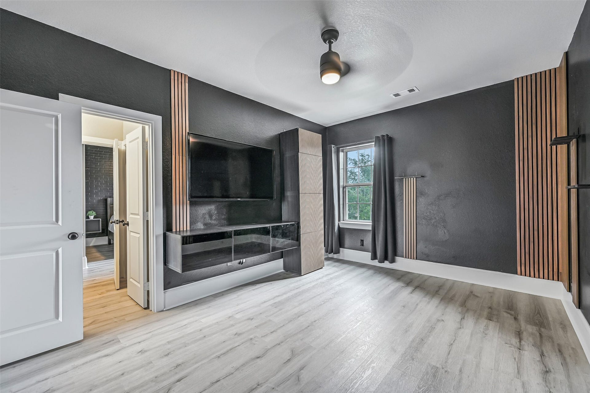 The fourth upstairs secondary bedroom offers LVP flooring, custom wood-slat accents, modern lighting and a step-in closet. It shares a Jack & Jill bath with the adjoining bedroom, completing the home's four-bedroom second-floor layout.