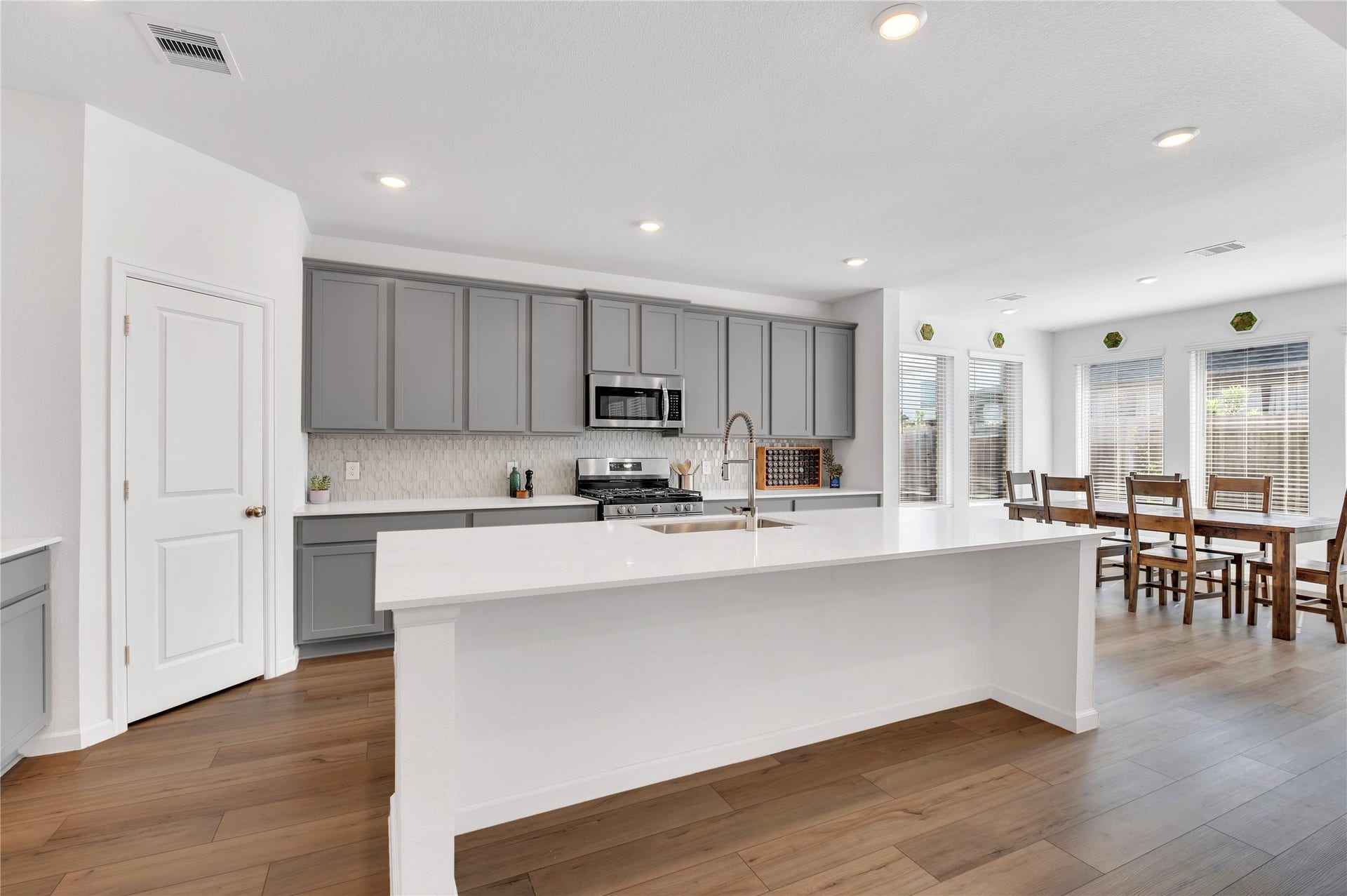 815 Wormwood Drive, League City, TX 77573 kitchen with beautiful natural light, quartz countertops, and a farmhouse style sink!