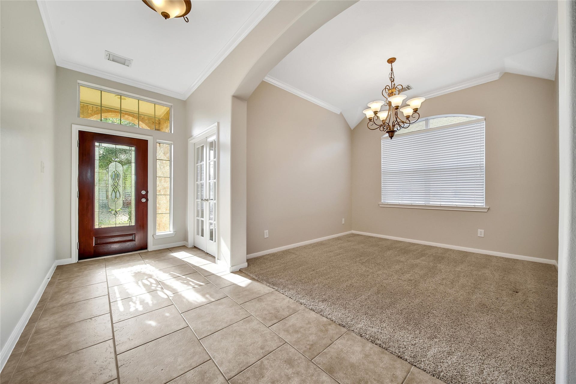 25604 Southwood Oaks Court, Porter, TX 77365 This bright foyer features a solid wooden door with decorative glass and a sidelight. Natural light streams through the transom and large window, fitted with blinds, and there's an adjacent study with french doors and an elegant dining room which could also be used as a game room or flex space.