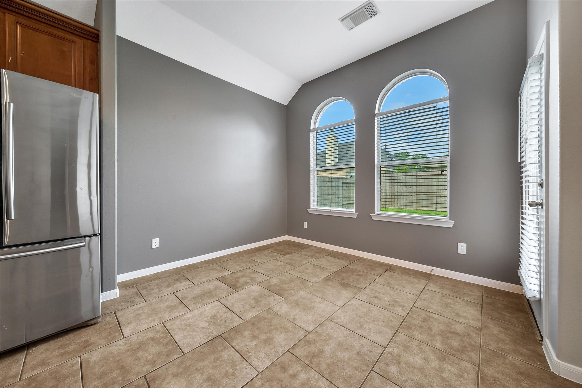 25604 Southwood Oaks Court, Porter, TX 77365 This is a bright, breakfast room open to the kitchen and living room, neutral gray walls, and two large arched windows that let in plenty of natural light. Enjoy views of the backyard through the arched windows.