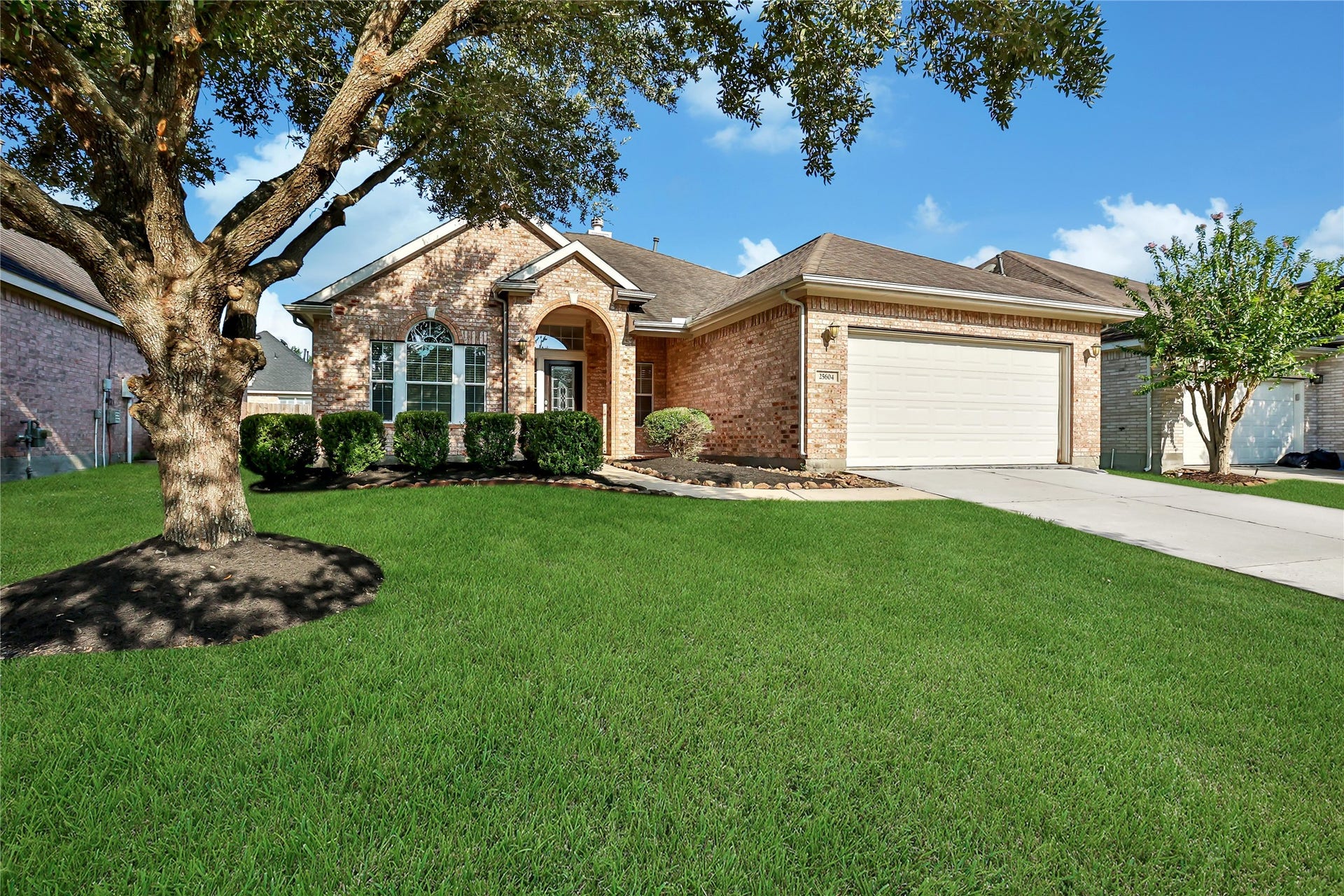 25604 Southwood Oaks Court, Porter, TX 77365 This is a well-maintained single-story brick home featuring a two-car garage, a mature oak tree in the front yard, and neat landscaping.