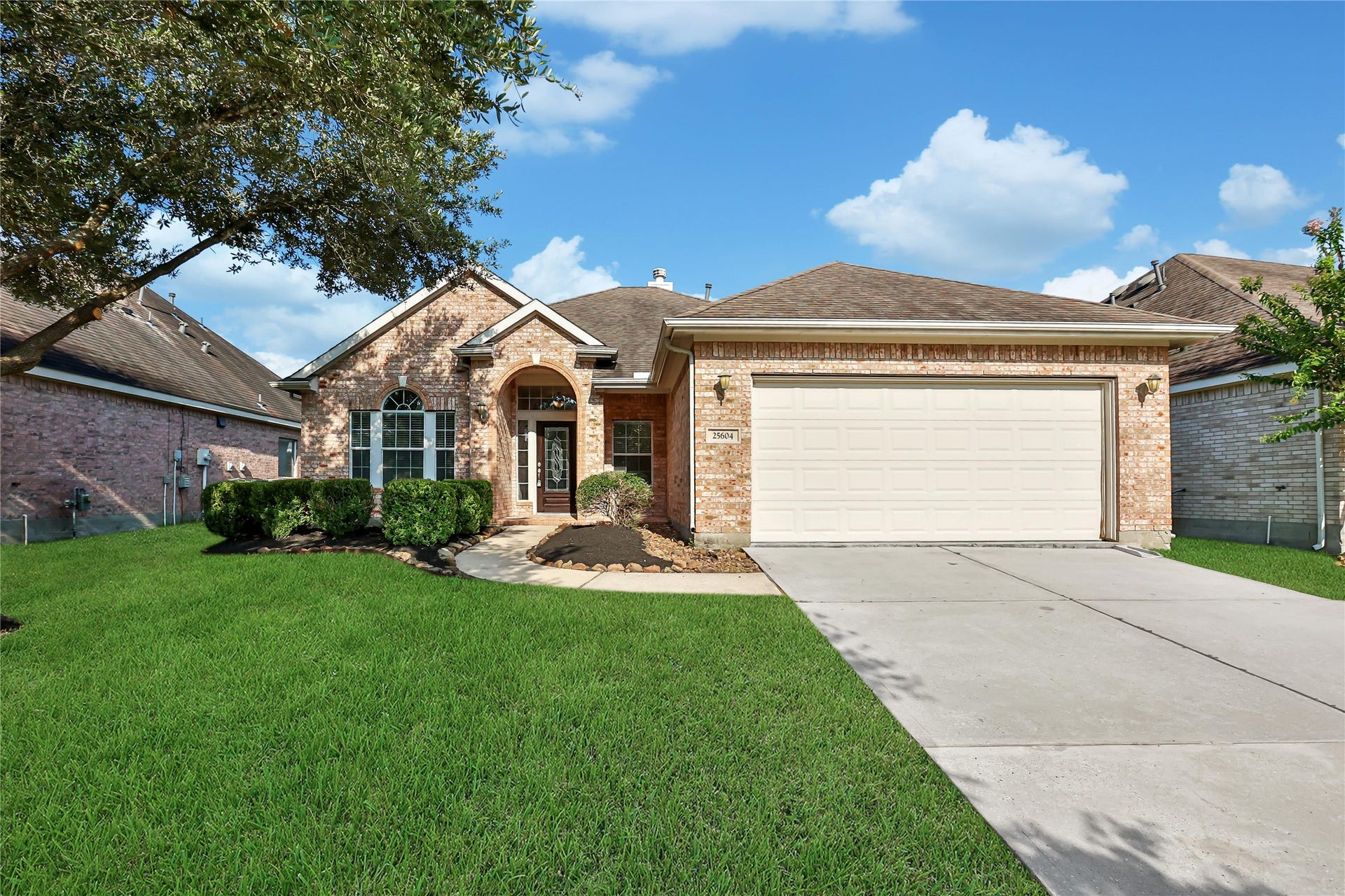25604 Southwood Oaks Court, Porter, TX 77365 This is a well-maintained single-story brick home featuring a two-car garage, a mature oak tree in the front yard, and neat landscaping.