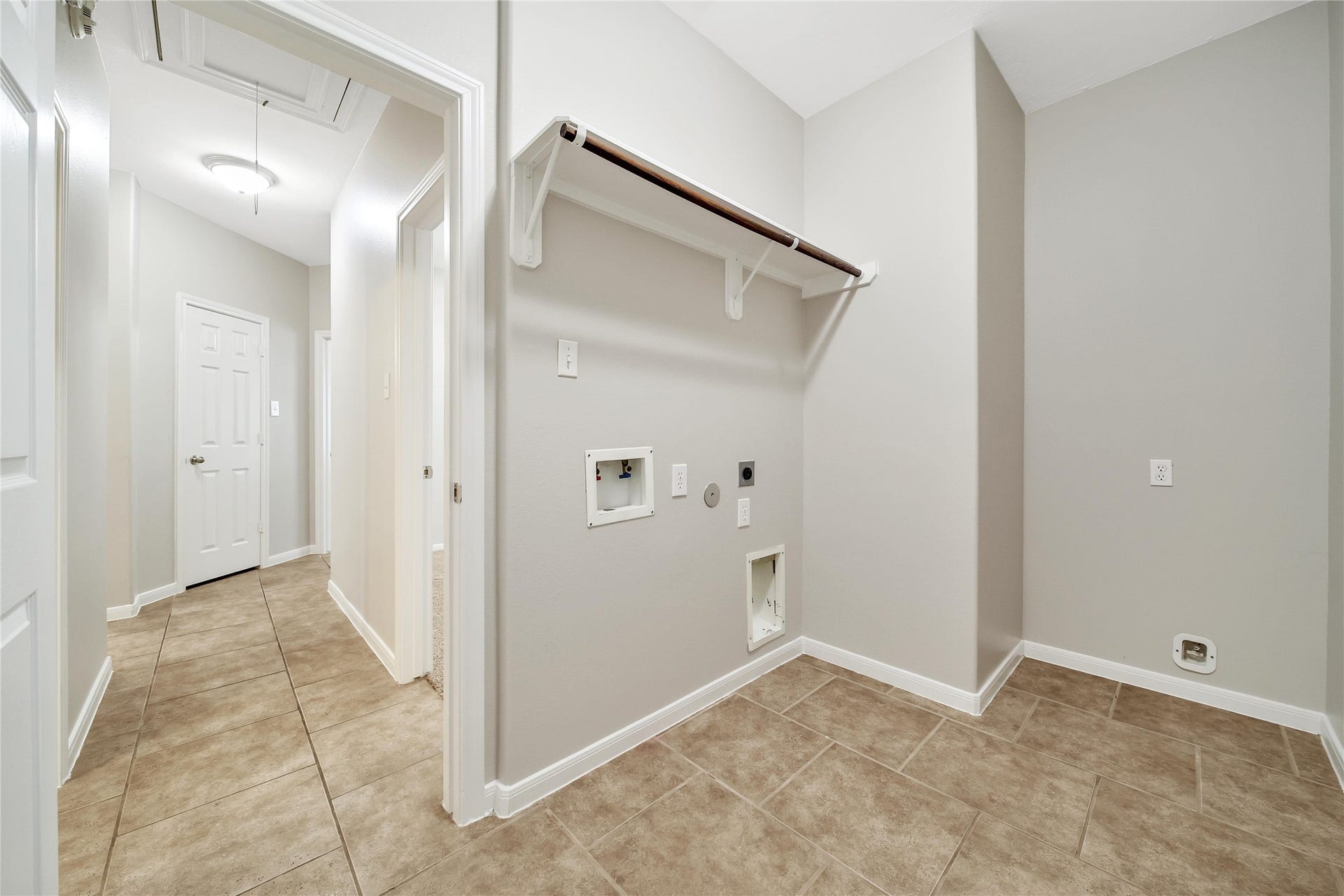 25604 Southwood Oaks Court, Porter, TX 77365 Spacious laundry room with hanging rack and room for a second fridge is located at the end of the split plan hall and has access to the garage.