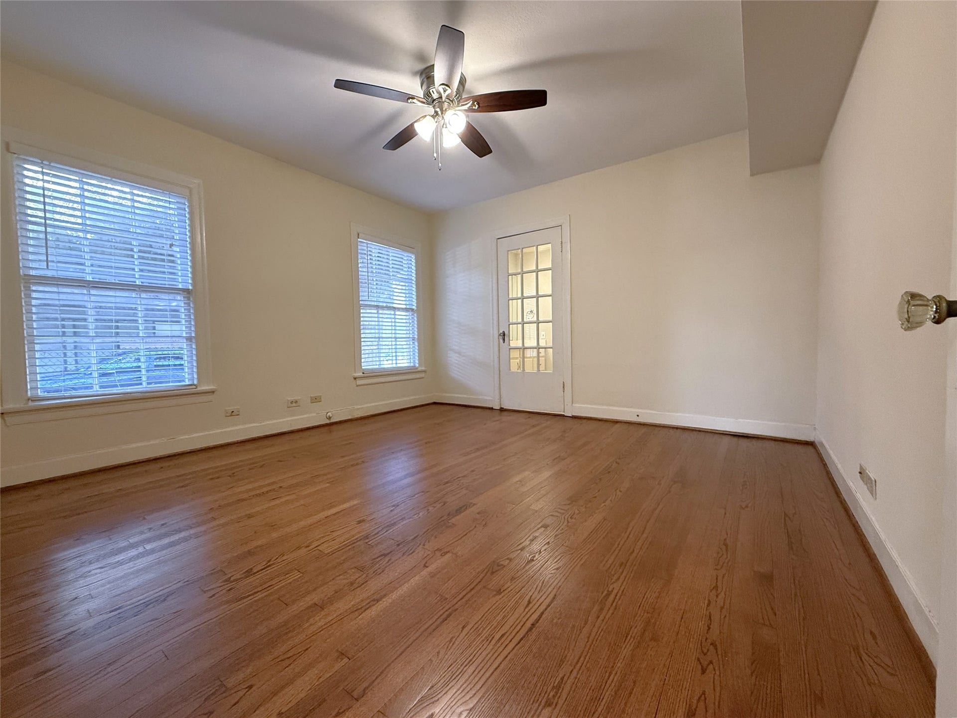 1968 Dryden Road, #1, Houston, TX 77030 The primary bedroom with ceiling fan. Beyond the glass paned door is the primary bathroom. On the far right, notice the vintage glass door knob.