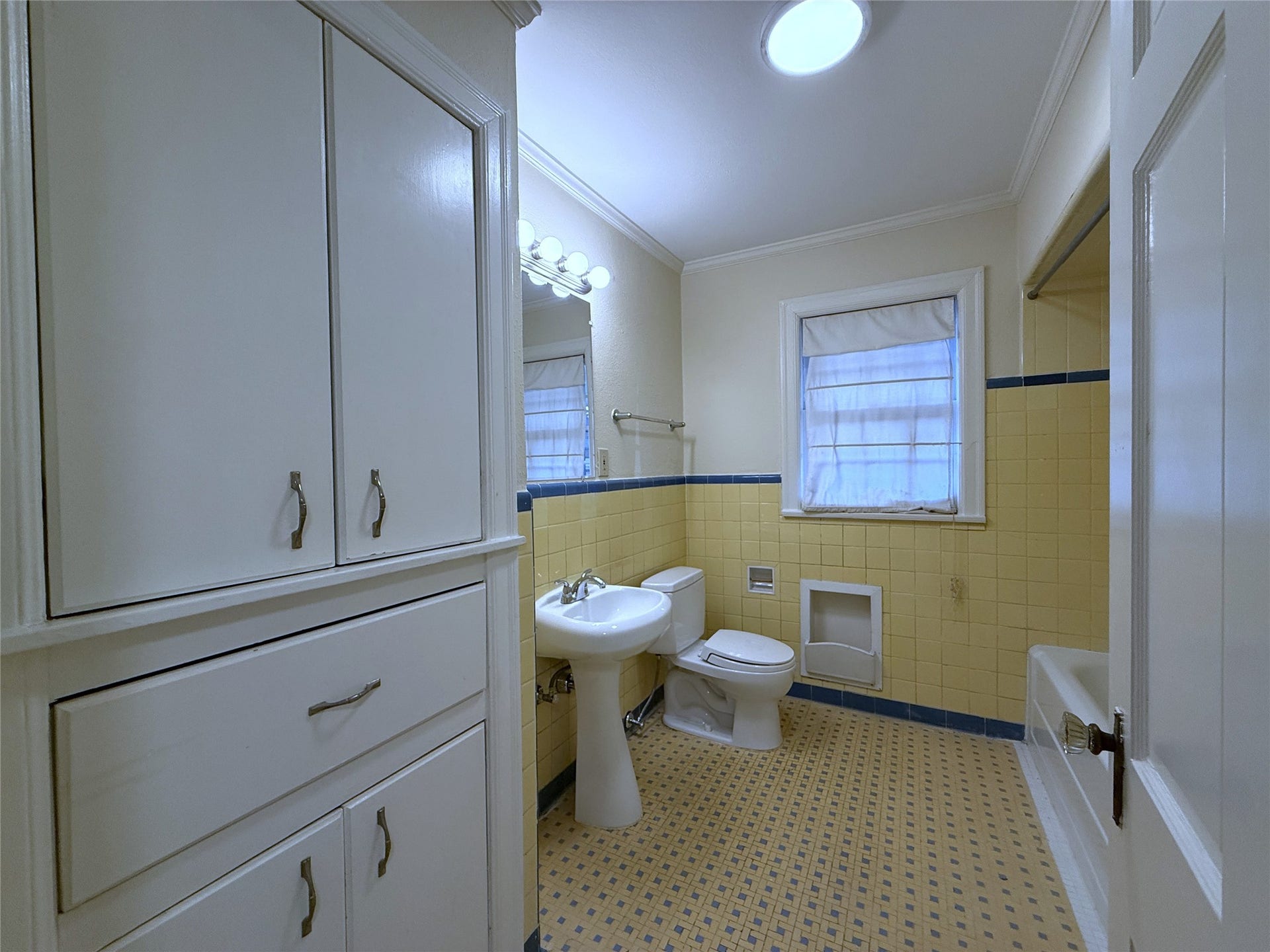 1968 Dryden Road, #1, Houston, TX 77030 The hallway bath features vintage tile, tub/shower combo, linen storage & built-in hamper.