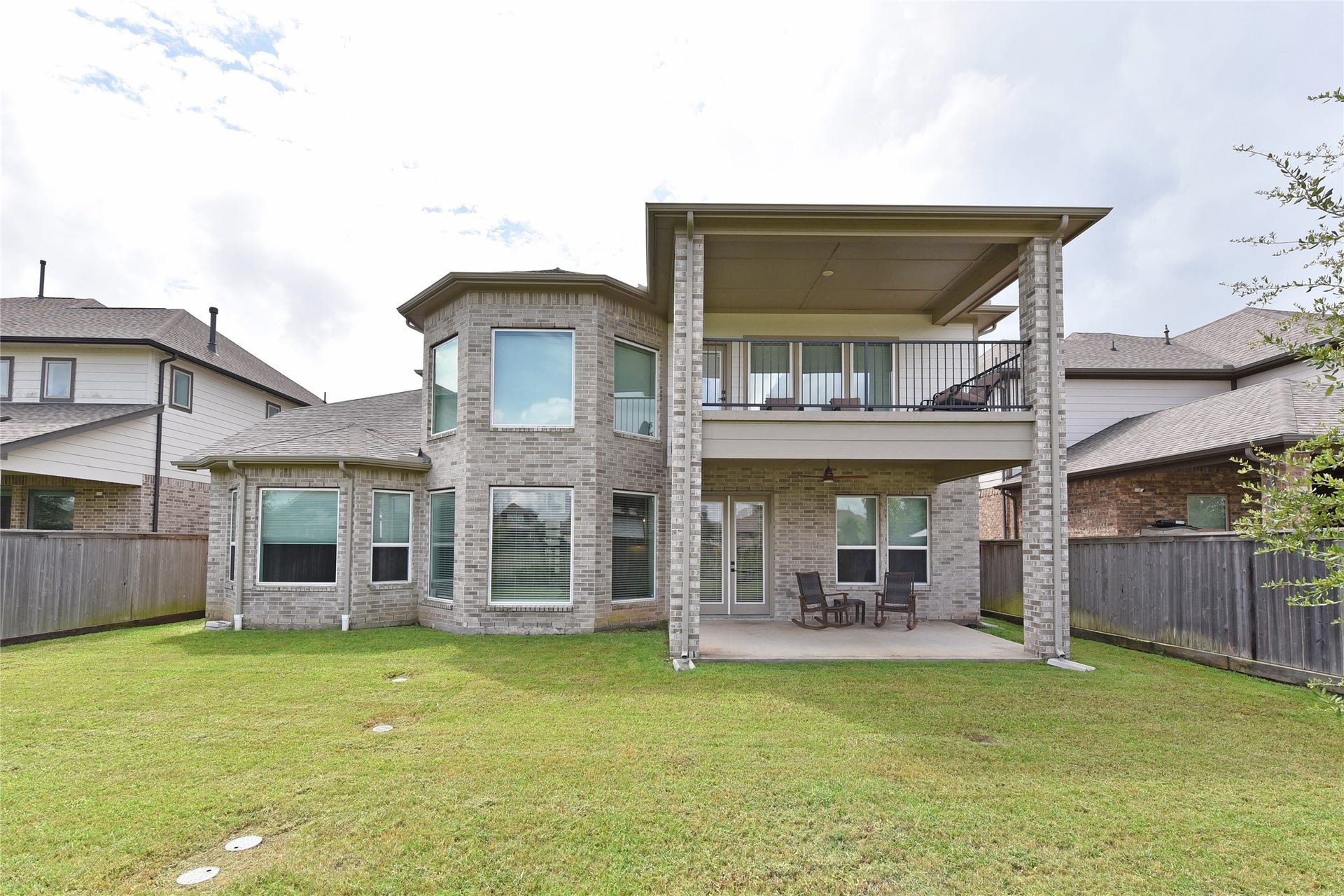 A rear view of the home.  Note all the windows that open out onto the green spaces.