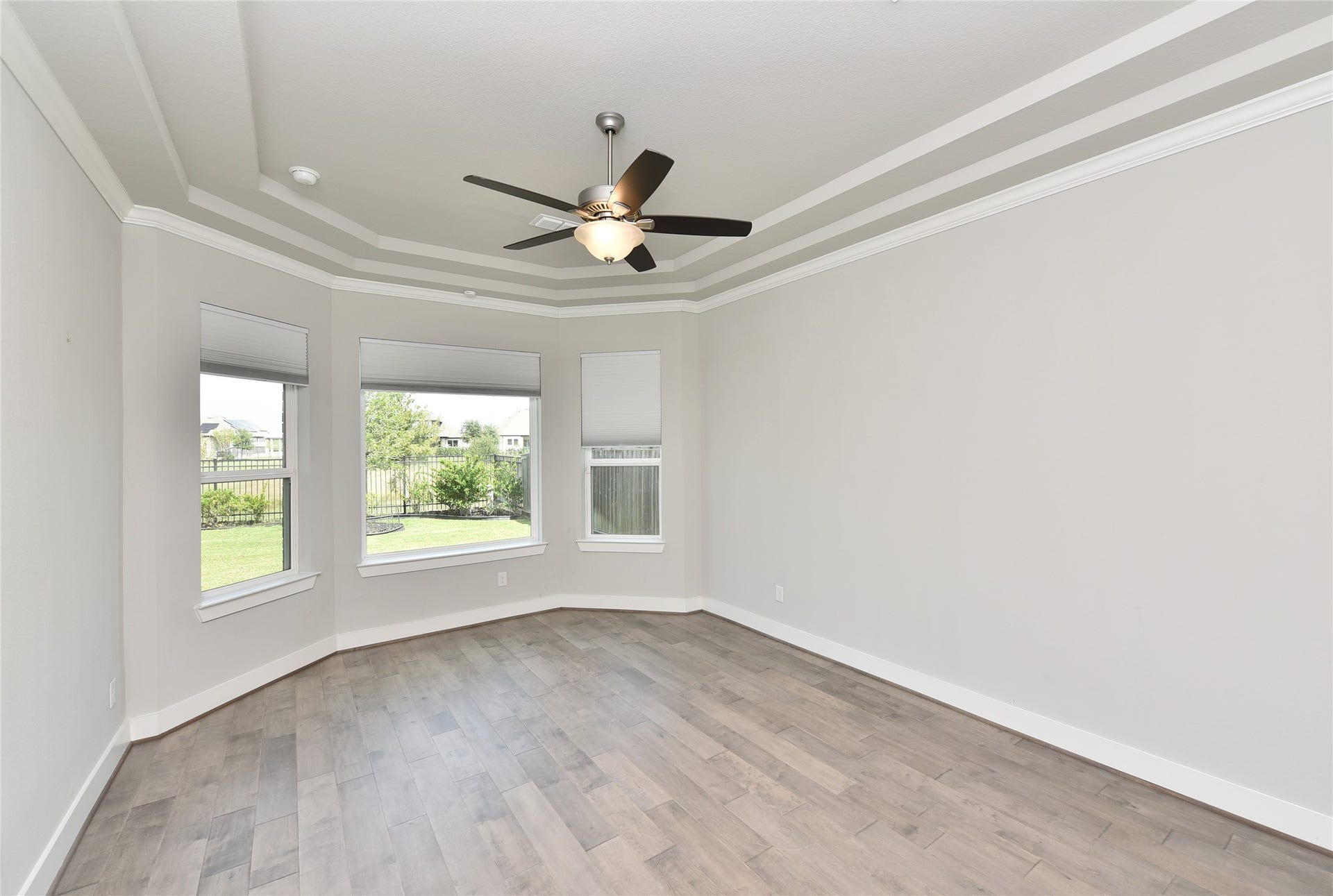 The primary suite floor is easy care engineered wood floor and includes sitting area overlooking beautiful green space out back.