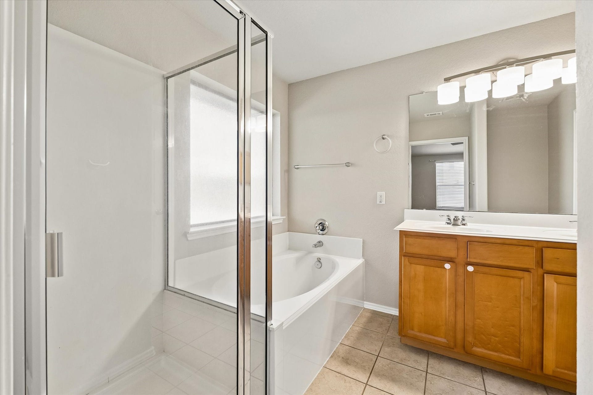 18127 Hillock Glen Lane, Cypress, TX 77429 Private primary bathroom featuring dual sinks, soaking tub, separate glass-enclosed shower, and generous vanity storage.
