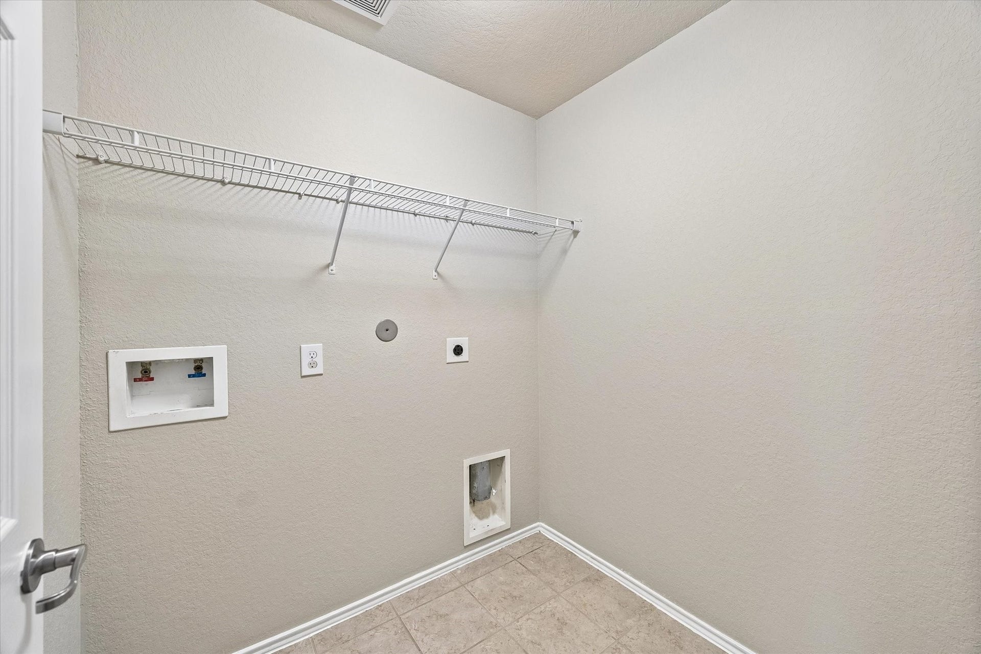 18127 Hillock Glen Lane, Cypress, TX 77429 Dedicated interior laundry room with washer and dryer connections and overhead storage shelving.