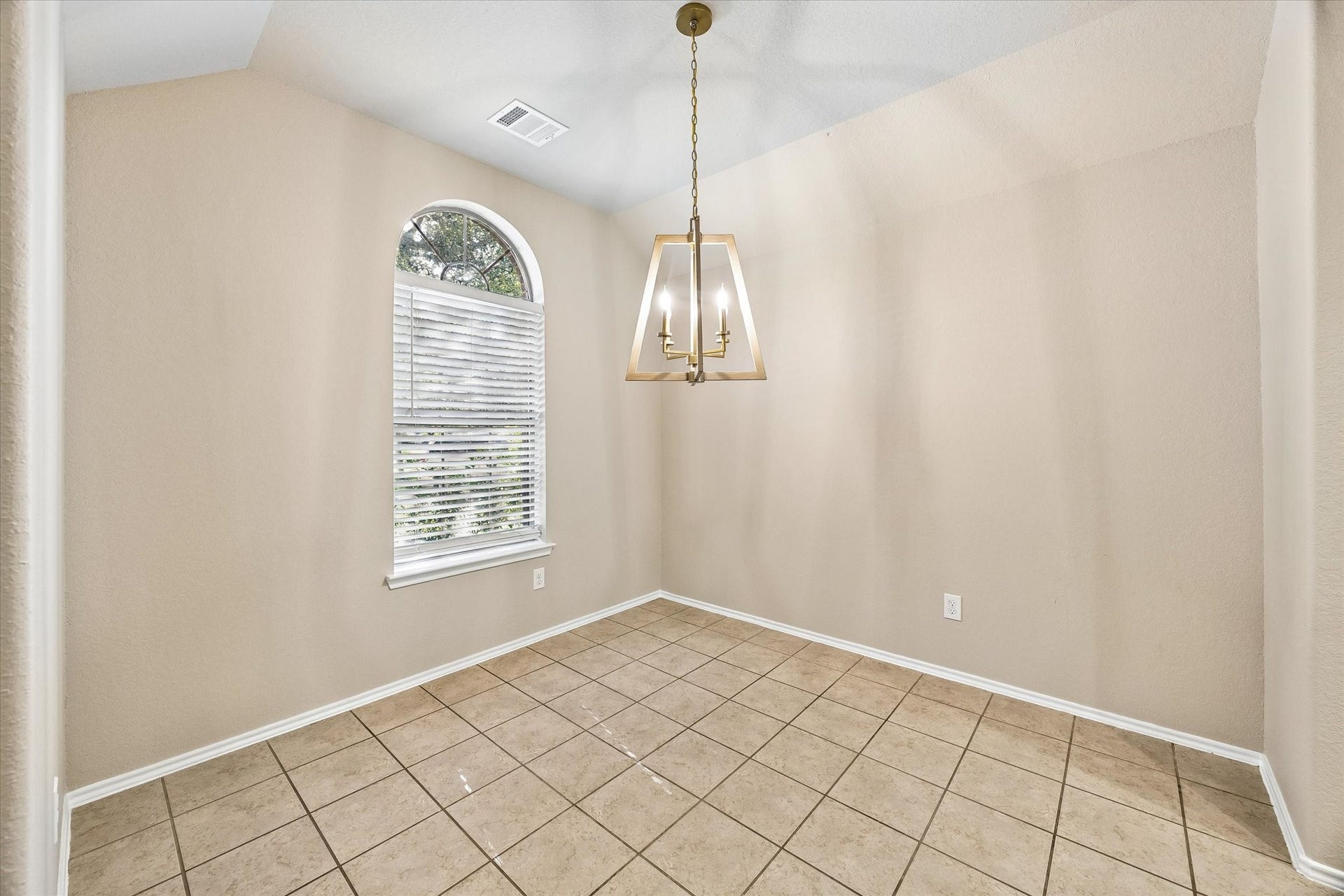 18127 Hillock Glen Lane, Cypress, TX 77429 Dining room featuring a vaulted ceiling, beautiful arched window, and newly updated chandelier. Perfect for hosting dinners and holiday gatherings.
